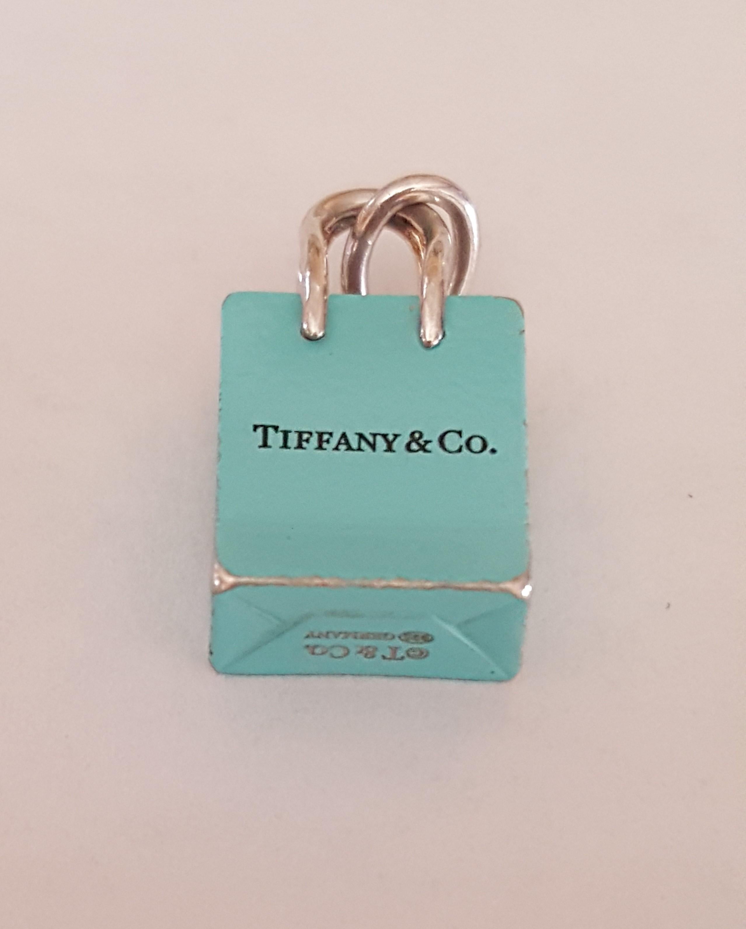 Pre-owned Tiffany & Co. Silver Signature Blue Purse Pendant , Enamel finish, Hallmark: T and Co. Germany, 11mm x 13 mm x 5.5mm in size. Good condition, the enamel has worn slightly on the bottom of pendant. Iconic piece for a Tiffany Co Collector.