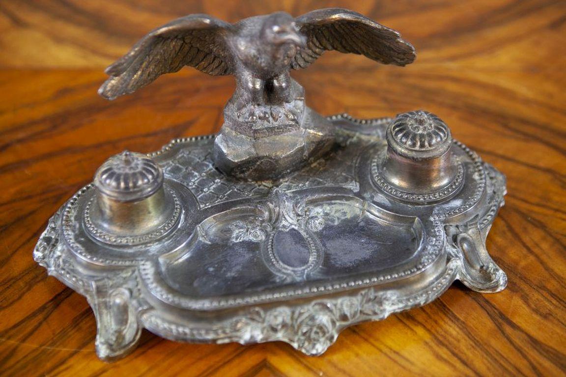 Pre-War Metal Inkwell with Bird Figurine

Metal inkwell with a bird figurine, dating back to the early 20th century. In good condition, one of the lids has a damaged hinge.