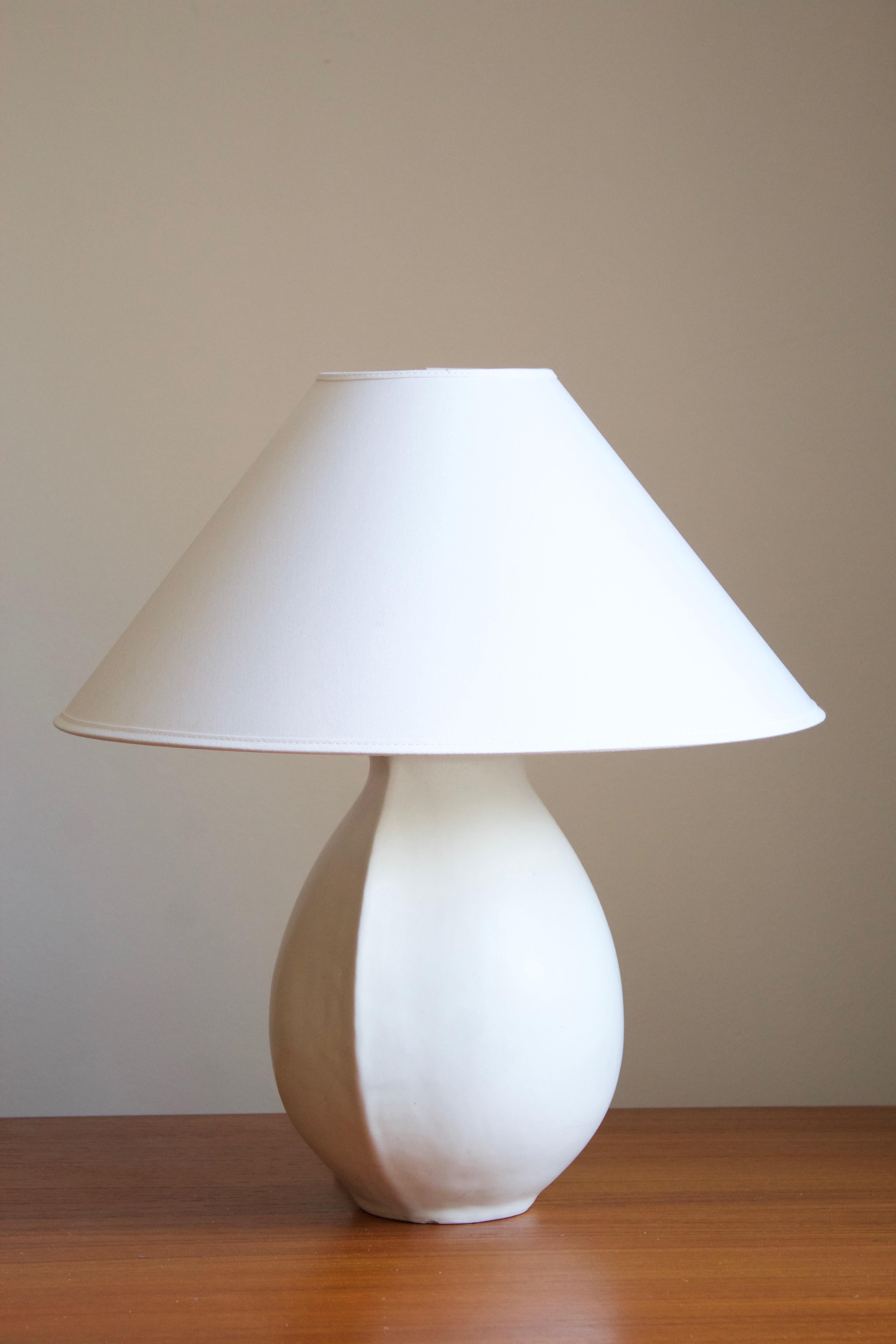 A sizable handmade table lamp. Designed and produced by Preben Brandt Larsen in his studio in Fejø, Denmark. Features matte-white glaze typical to artists. 

Glaze features a white color.

Sold without lampshade. Stated dimensions exclude the