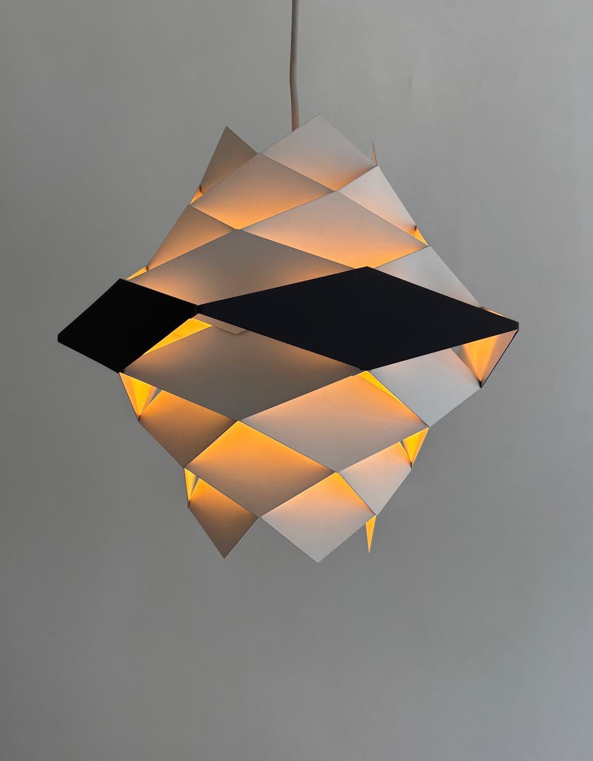 La lampe suspendue rhomboïdale Symfoni, conçue dans les années 1960 par le designer danois Preben Dahl pour Hans Følsgaard, est un exemple emblématique de l'éclairage moderne du milieu du siècle. Caractérisée par sa construction géométrique