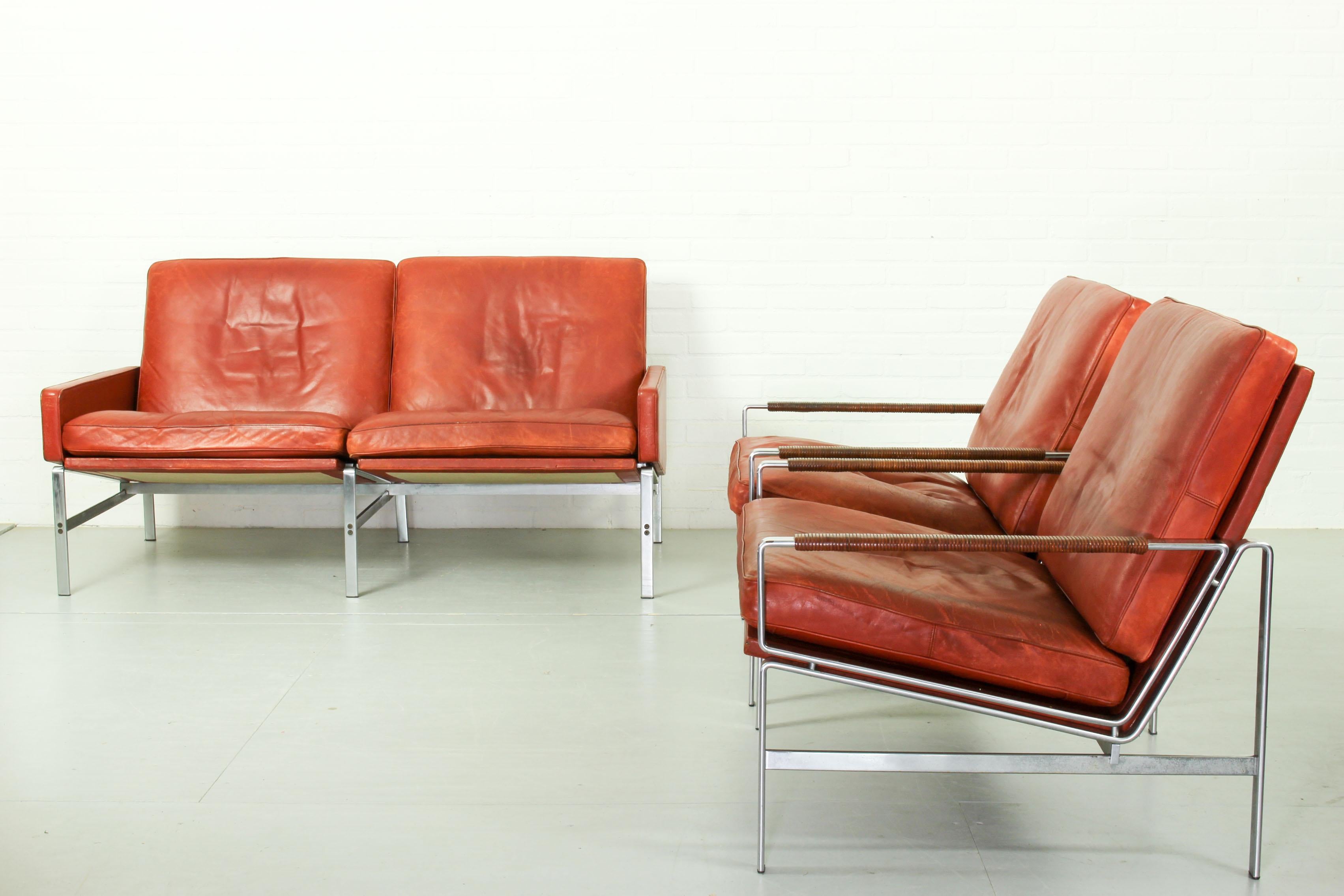 Preben Fabricius & Jørgen Kastholm lounge set model FK 6720. This beautiful lounge set consisting of two-seater sofa and two arm chairs with matte chrome-plated steel frame is upholstered with the original orange-red leather. Designed in 1968.