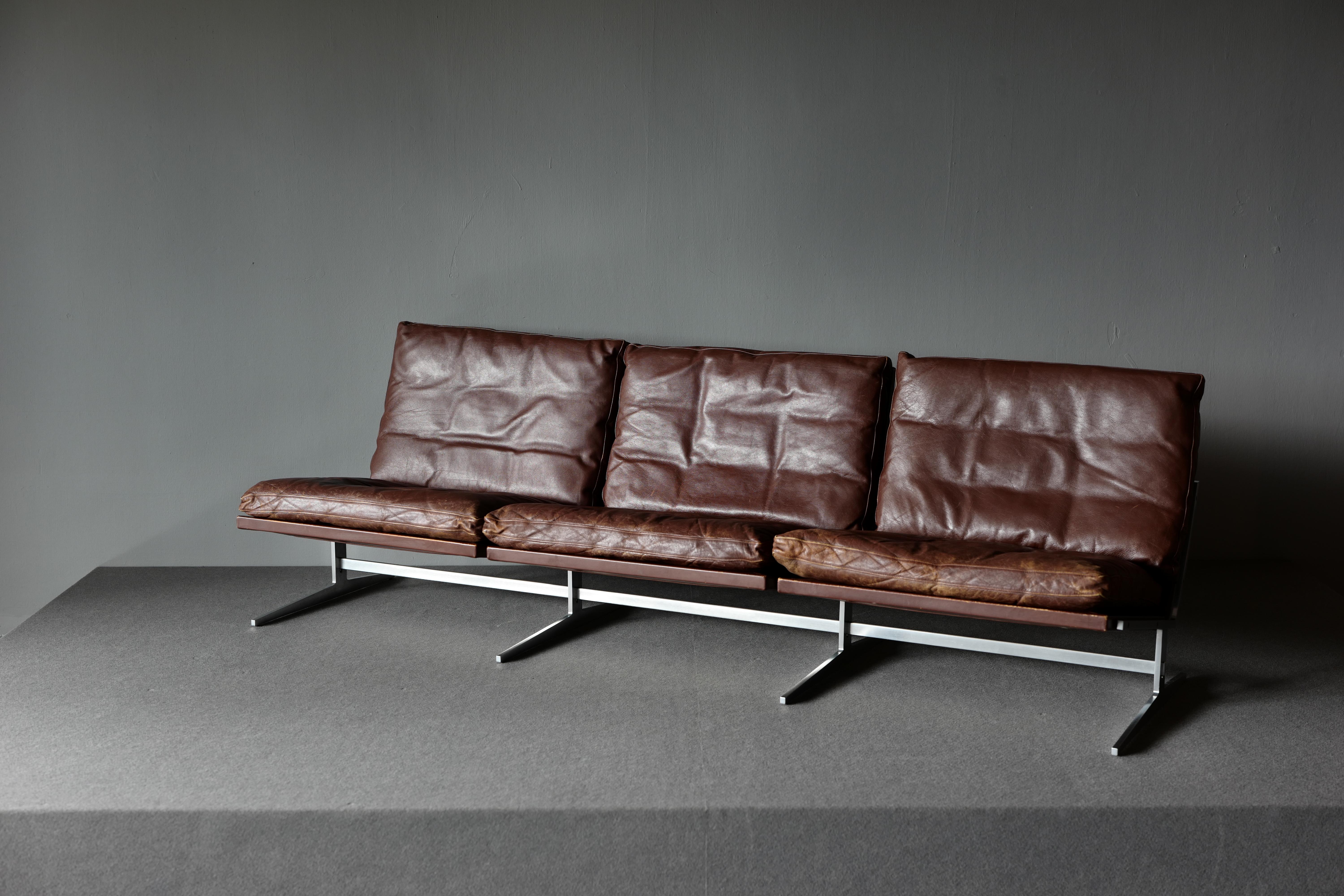 Very rare three-seat sofa by Preben Fabricus and Jorgen Kastholm for Bo-Ex. This sofa is executed in steel with the back and loose cushions upholstered in well patinated brown leather. It also has neck cushions that need to be mounted on the wall.