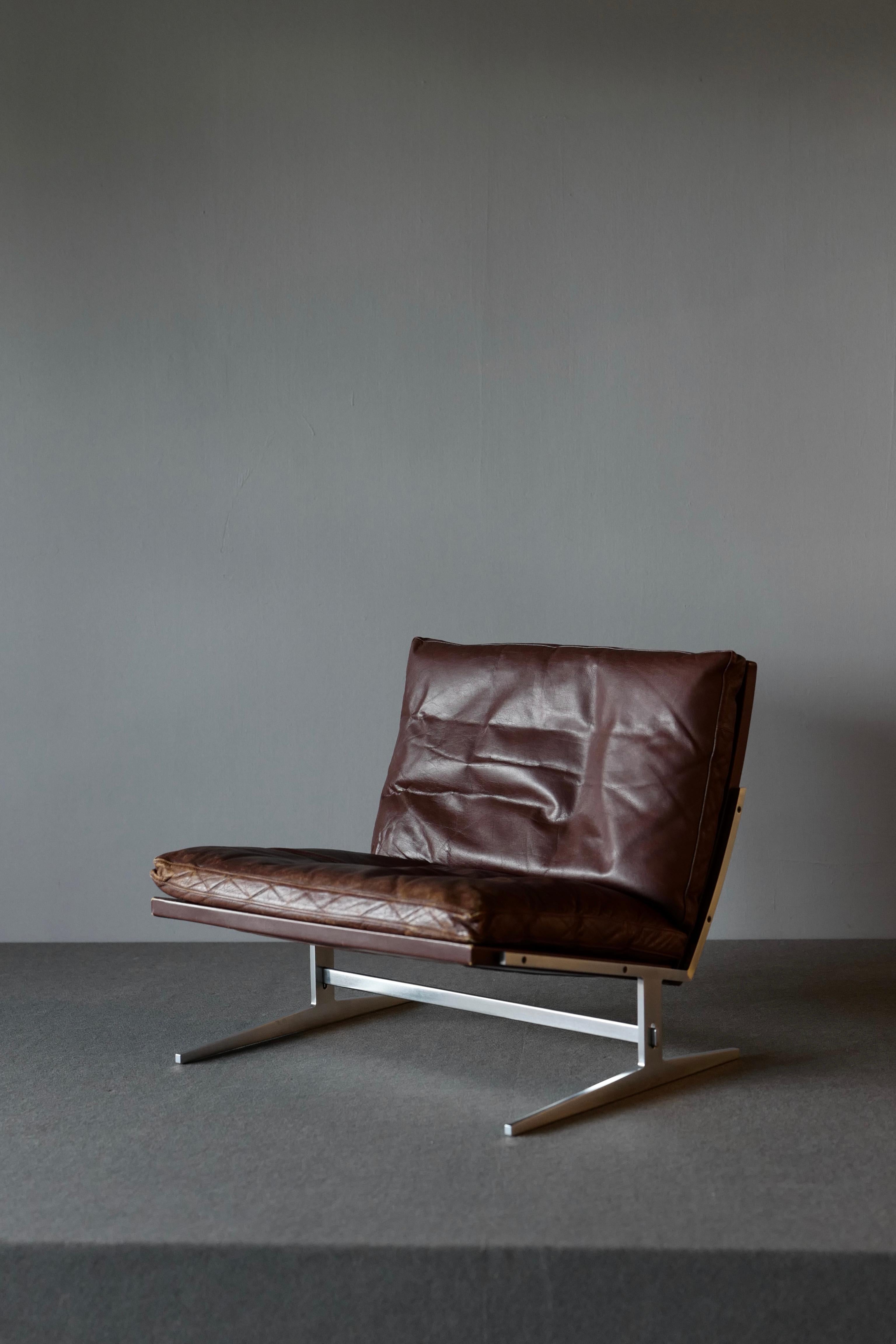 Chair by Preben Fabricus and Jorgen Kastholm for Bo-Ex. The chair has the distinctive tilted L-shaped seat and the double L-shaped base. It is executed in steel. The back and loose cushions are upholstered in well patinated brown leather. The