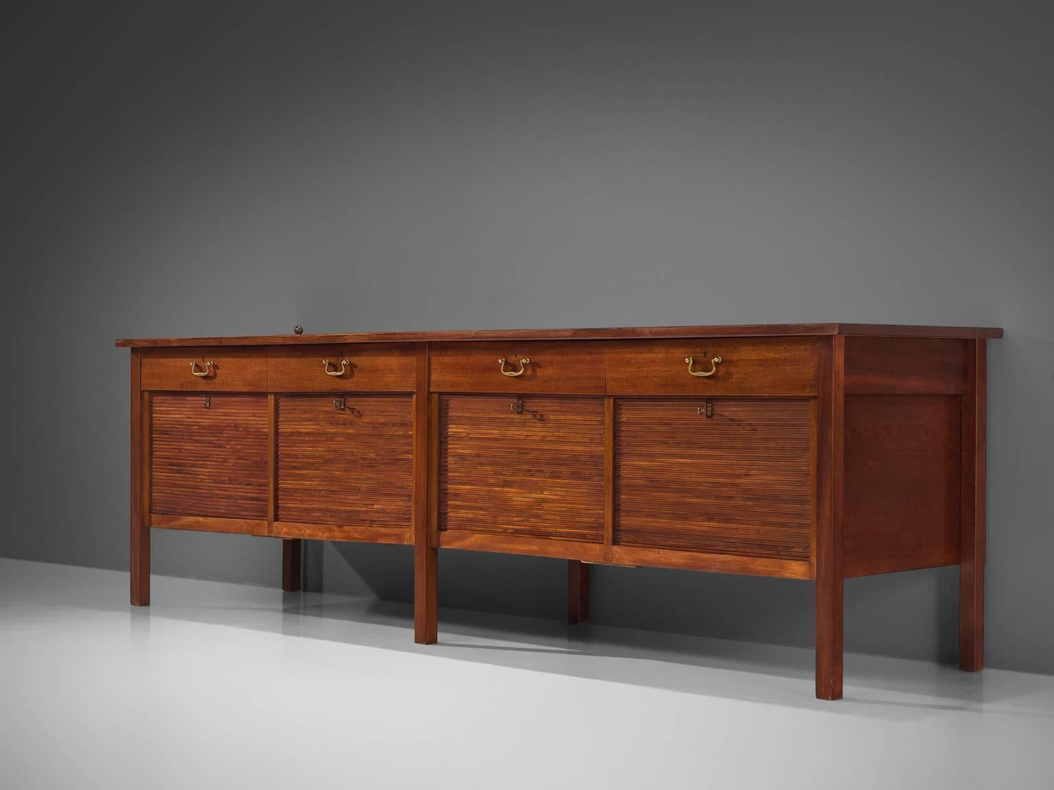 Preben Hansen for Peter Petersen, cabinet, teak and brass, Denmark, 1940s.

This Classic sideboard features a combination of Classic traits such as the tambour doors and rich materials such as the rich colored patinated brass and the dark teak.