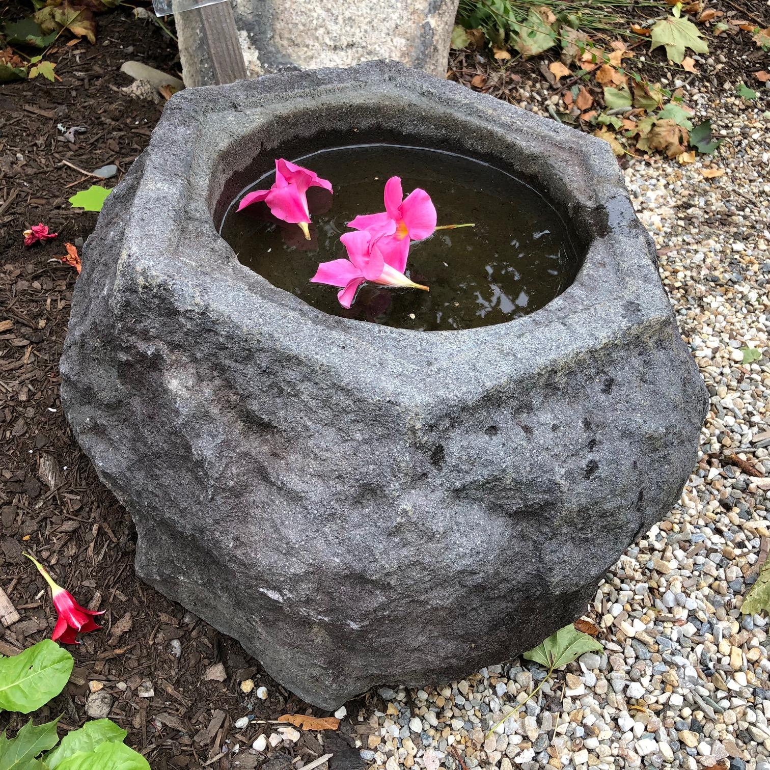 Japan, a handsome and unique antique natural shaped stone water basin planter -tsukubai- created from a natural mountain boulder and sourced from a decades old garden. Its hexagonal top has been carefully hand carved to reveal even more surface