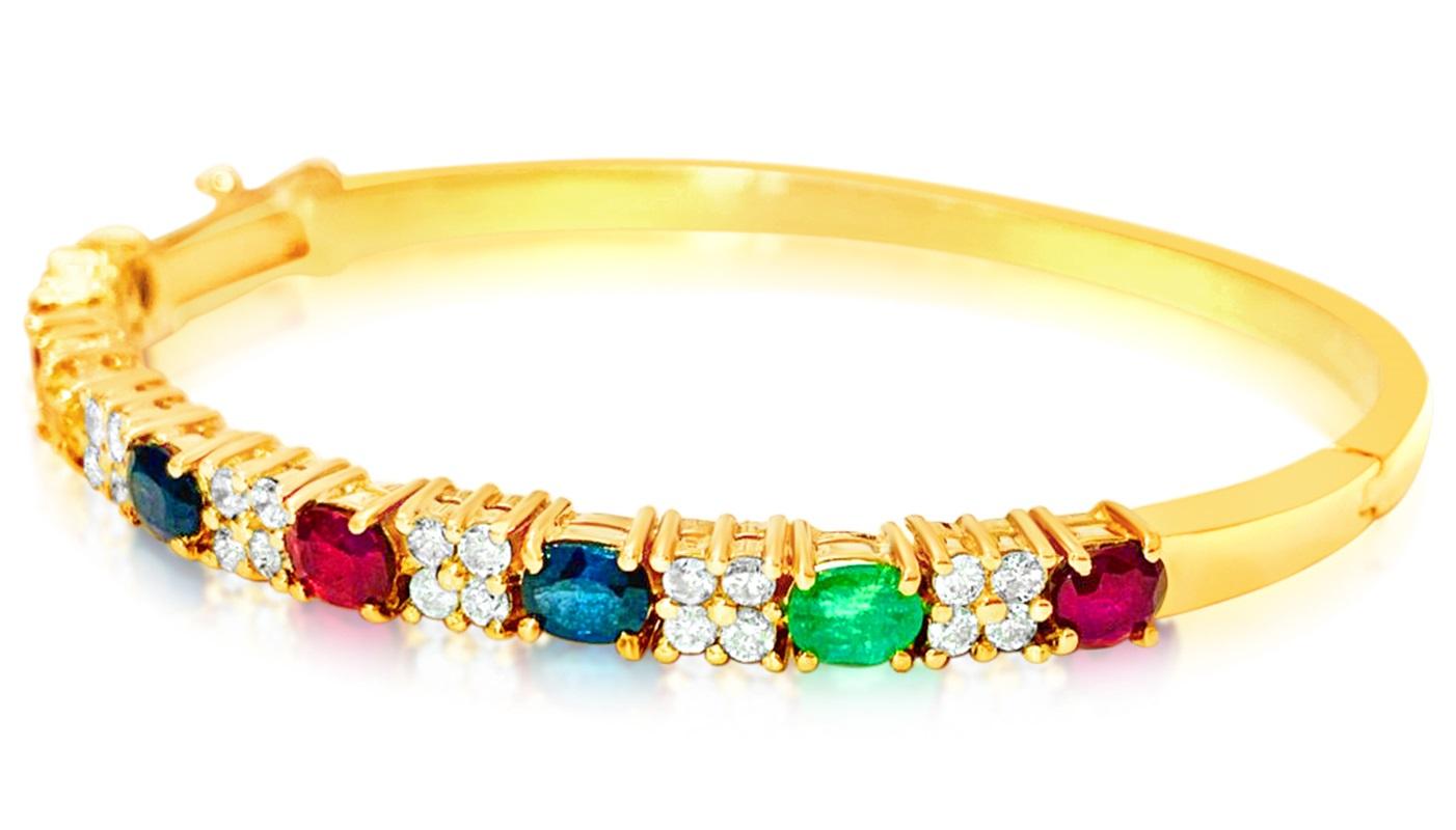 L'oro giallo 18 carati fa da sfondo a questo splendido bracciale impreziosito da gemme preziose. Ogni rubino, zaffiro blu, zaffiro giallo e smeraldo di taglio ovale, del peso di 0,75 carati, è saldamente trattenuto da rebbi, per mostrare la loro