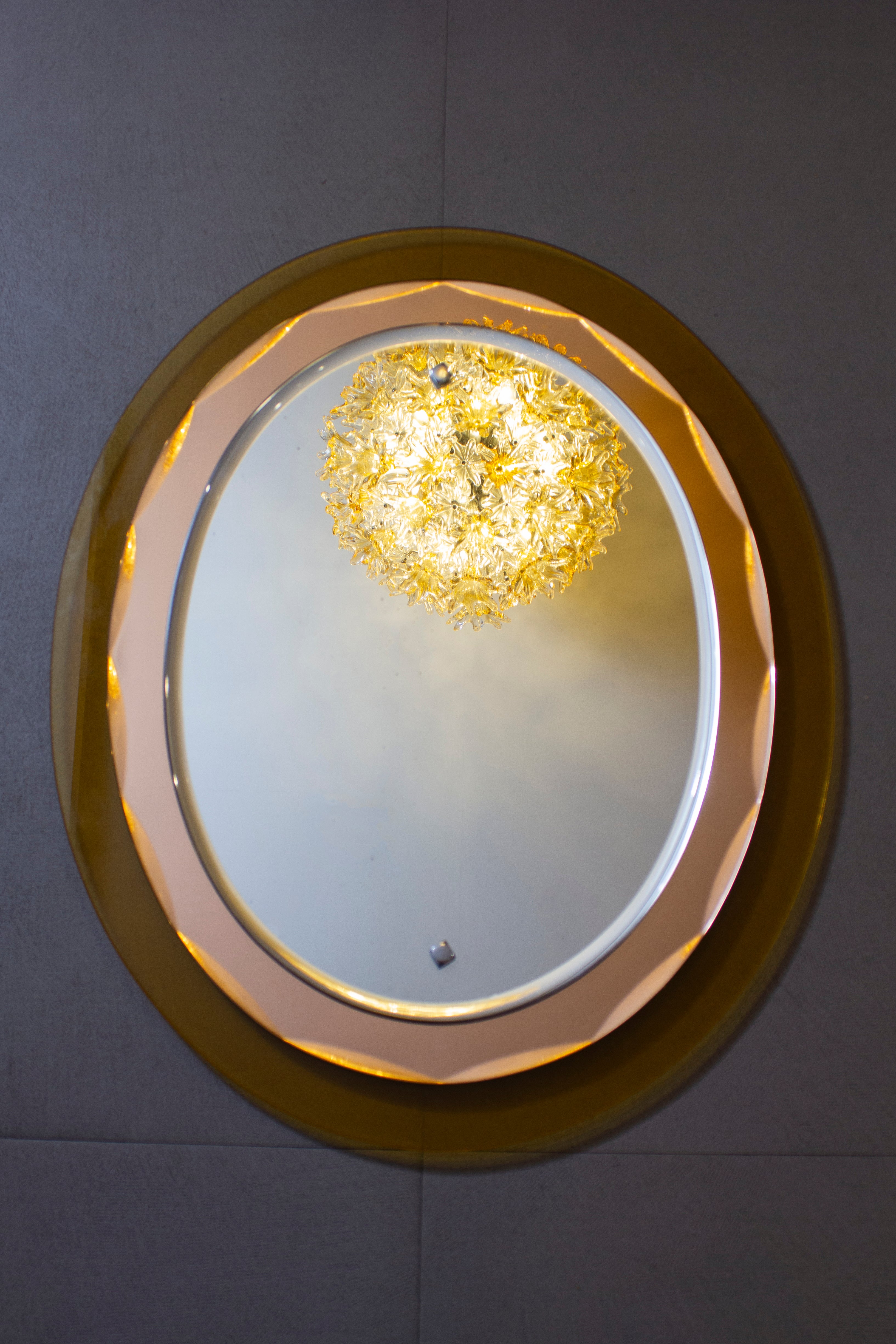 Beautiful mirror attributed to Max Ingrand for Fontana Arte. The mirror is in peach and and amber colored faceted glass framed. 
 Very good vintage condition.  We will deliver carefully packed in a wooden case and insured . 
It is a reflection of