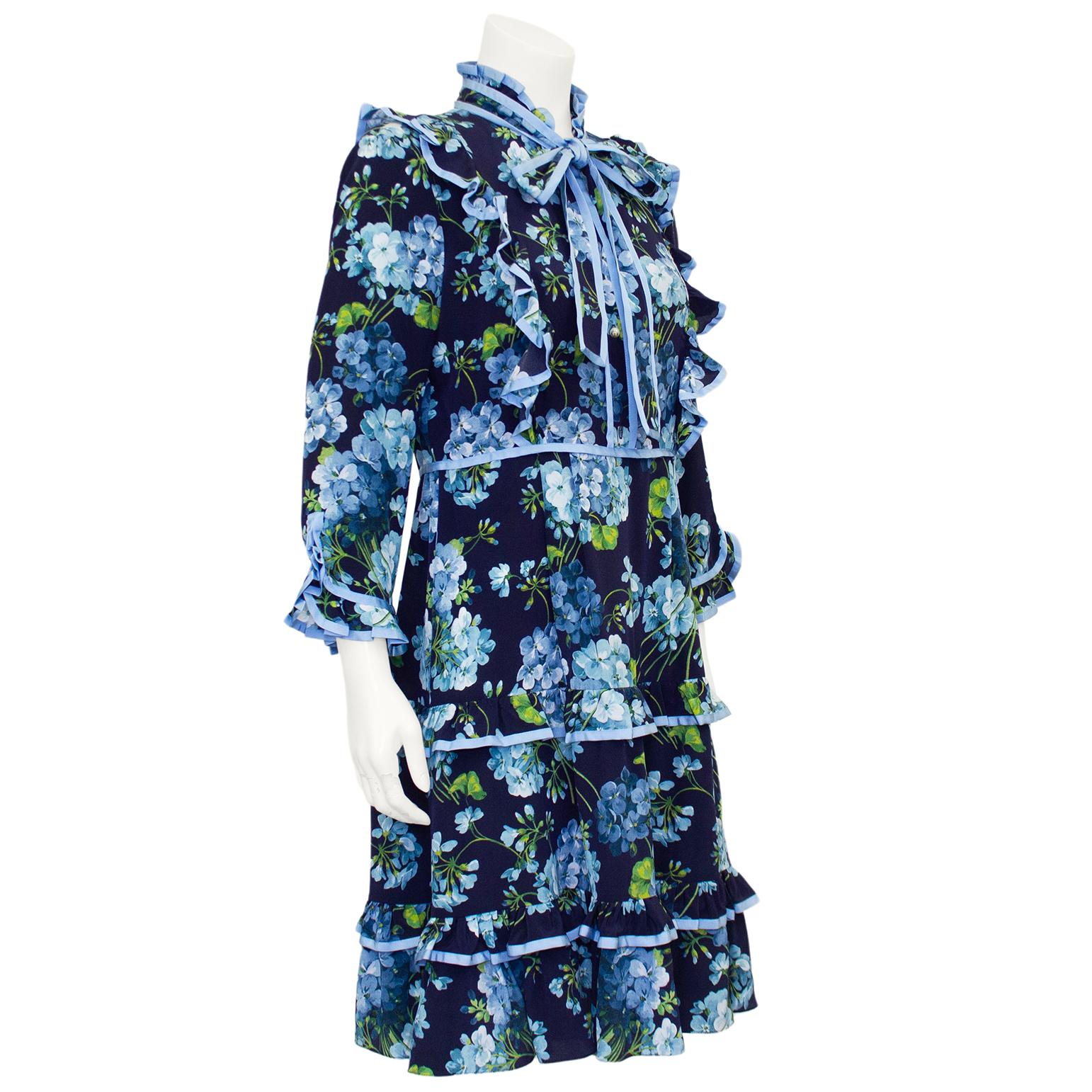 Gucci 2016 pre fall silk crepe floral printed maximalist dress by Alessandro Michele. Navy blue with all over pale blue and green hydrangea print. Ruffled neckline, yoke, cuffs and skirt. High neckline with pussy bow tie with faux pearl Gucci