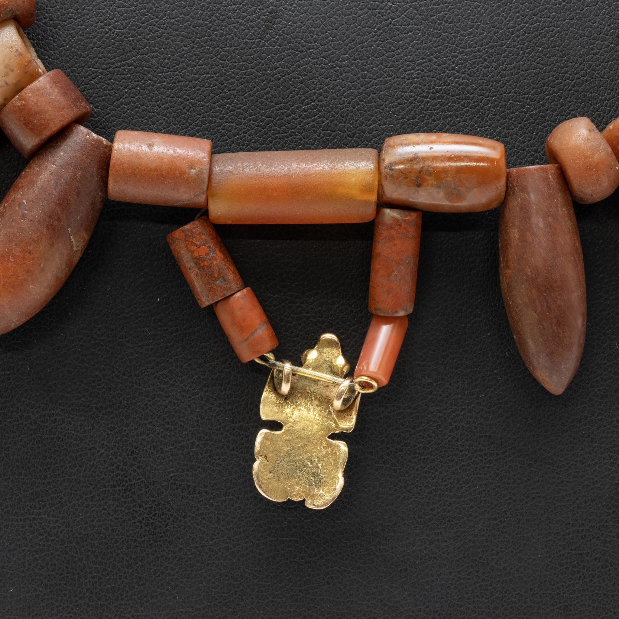 Pre-Columbian, Northern Colombia, Tairona culture, circa 800 to 1500 CE. A wonderful necklace of wearable form constructed with dozens of hand-carved carnelian beads. Dozens of additional greenstone beads line the upper portion of the necklace while