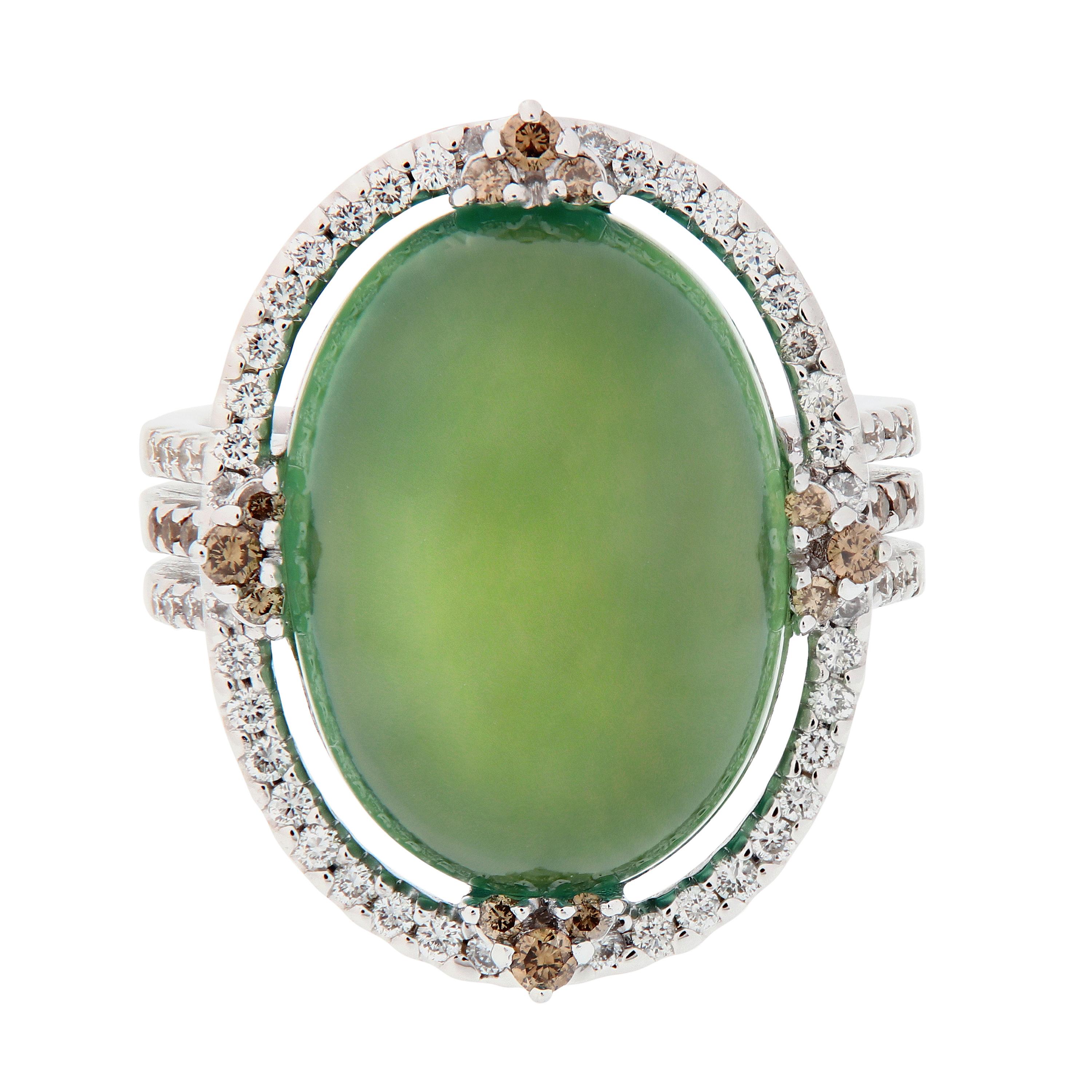 This 18k white gold ring centers around a cabochon cut Prehnite. An intriguing gemstone that features a unique green glow and is known as the stone of prophecy, aiding in spiritual communication through meditation. Center stone is accented with