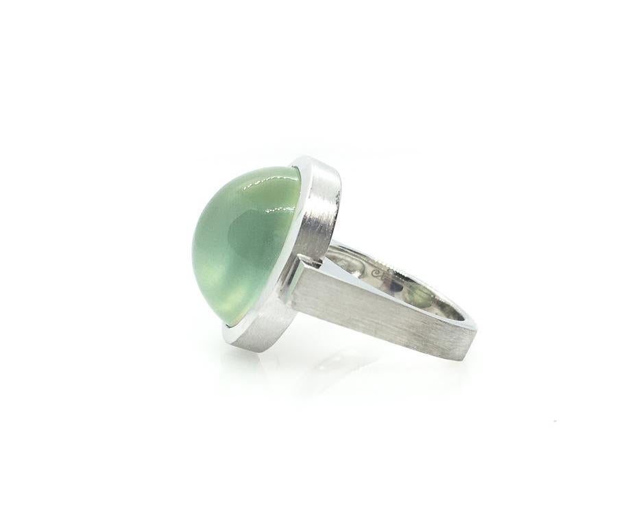 Mystically luminous green, this 17 ct. Prehnite Cabochon Oval is set vertically along the finger in a rhodium plated, sleek, Sterling Silver bezel and squared shank with contrasting high polish and sandpaper finishes for an elegant