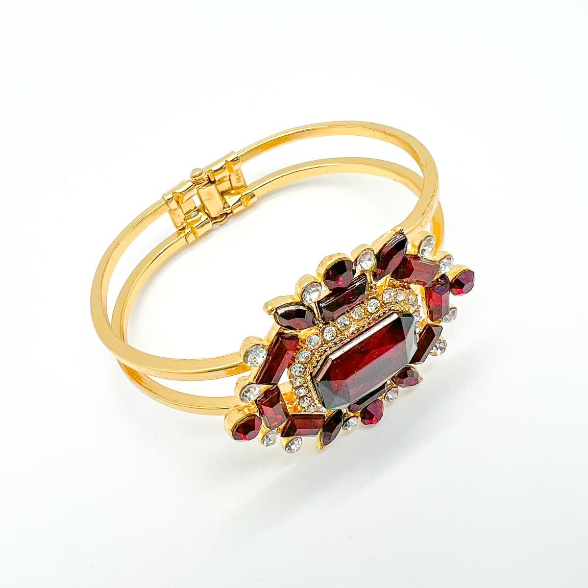 A striking Victorian Inspired Clamper Bangle. Garnet coloured stones in various fancy cuts steal the show. Adorn your wrist with this glamorous finishing touch.

Vintage Condition: Very good without damage or noteworthy wear.
Materials: Gold plated