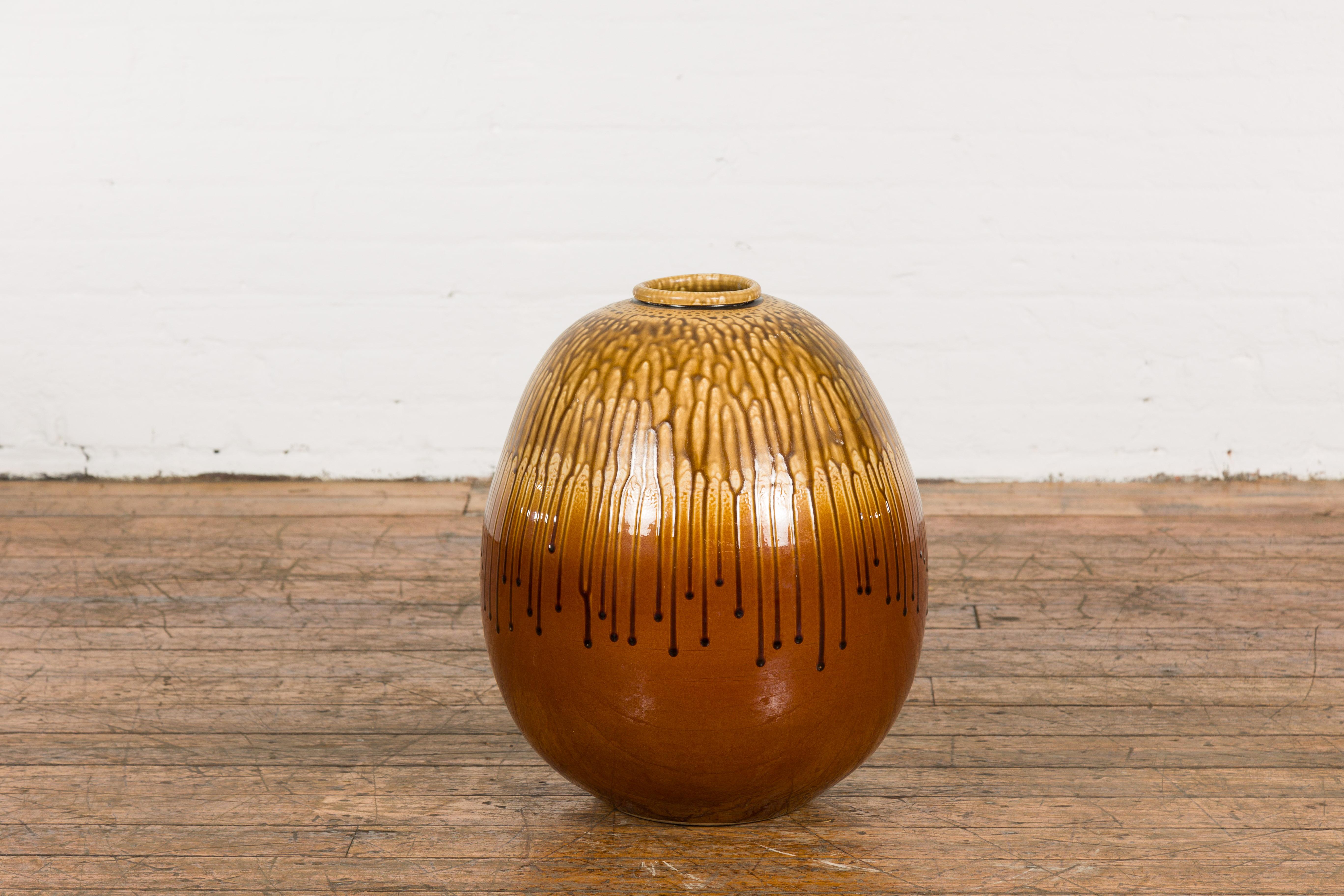 A Prem Collection ceramic artisan handcrafted two toned vase with brown, yellow and orange glaze and dripping motifs. Breathe life into your space with this artisan handcrafted ceramic vase from the Prem Collection. Displaying an exquisite blend of