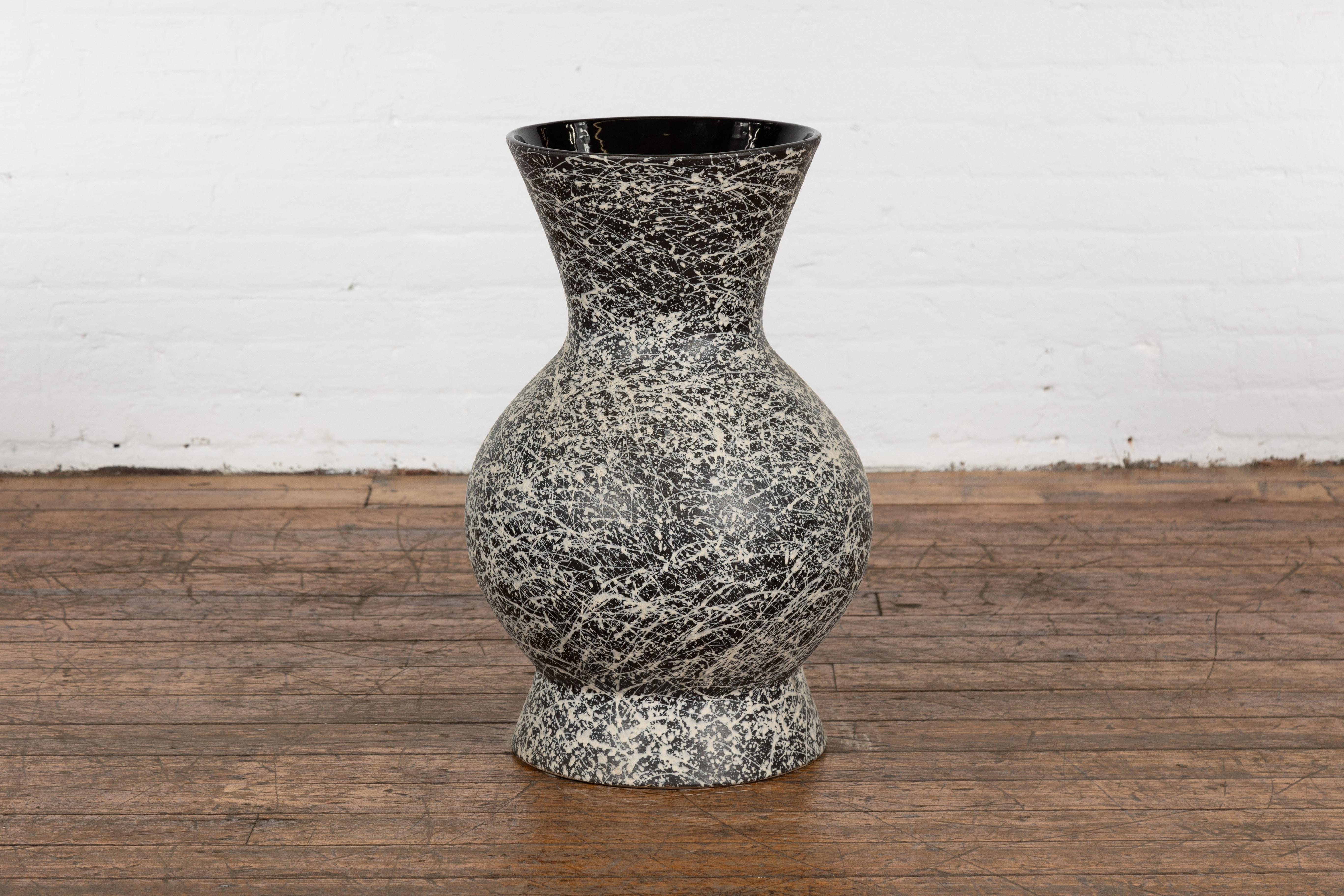 An artisan Prem Collection ceramic vase with nice rounded shape, black ground, white dripping décor and black glazed interior. Charming our eyes with its graceful lines, nice proportions and stylish décor, this vase is hand-crafted from ceramic. The