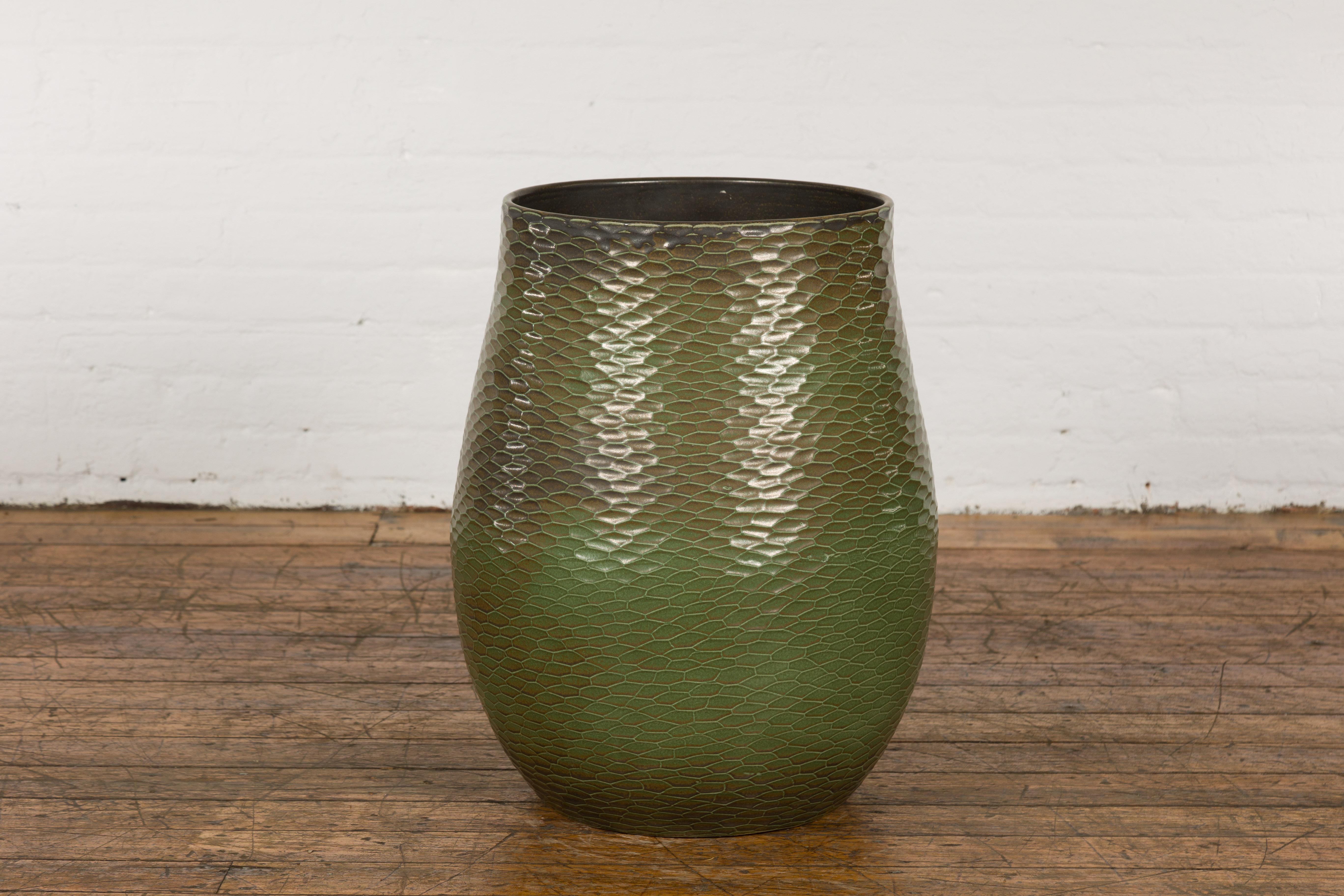 Vase en céramique de Prem Collection fabriqué à la main, avec une finition texturée verte et brune, une forme de poire, des motifs de style nid d'abeille et une large bouche. Avec ses lignes épurées et sa finition richement colorée, ce vase en