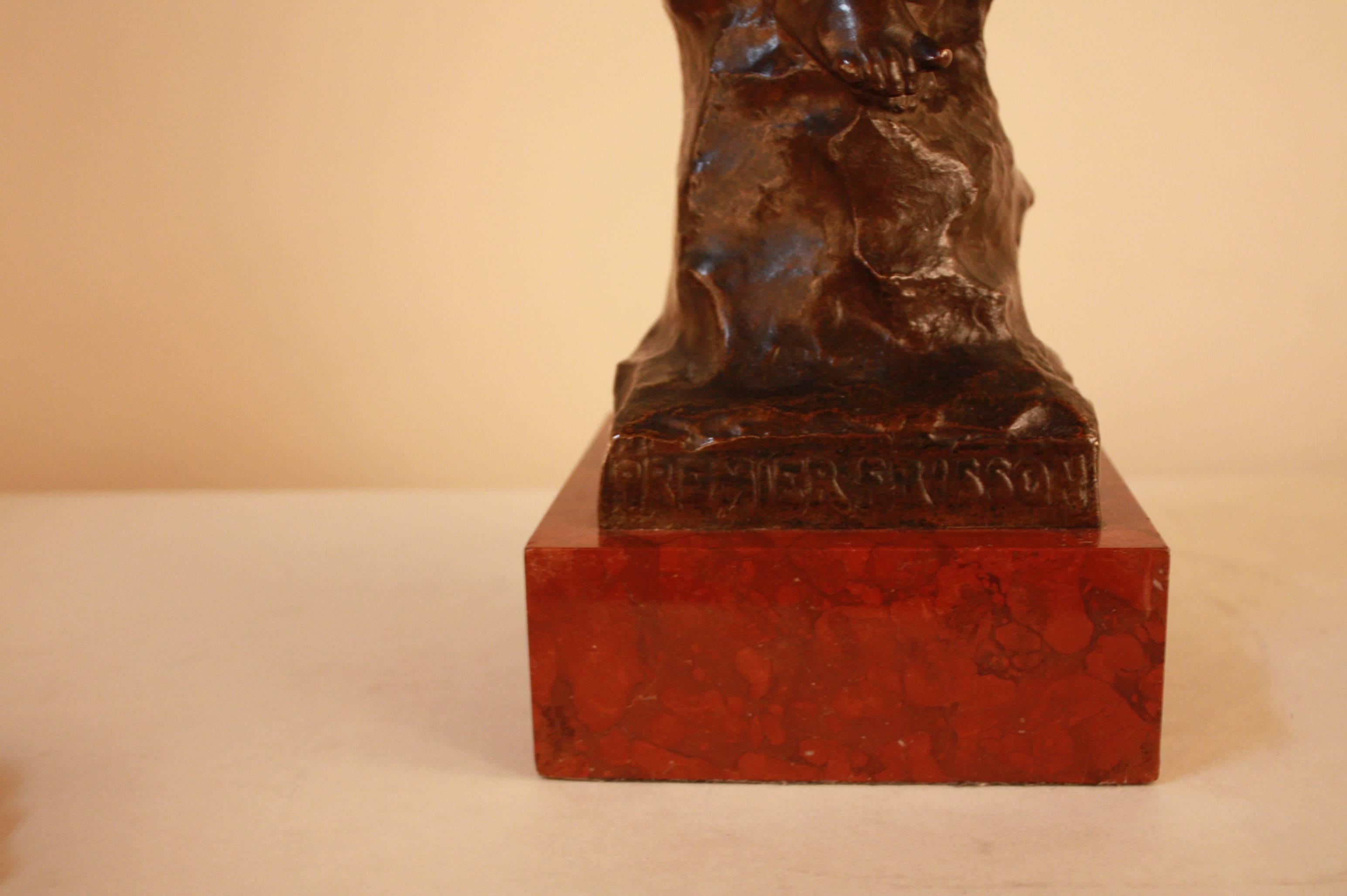 Late 19th century dark brown patina bronze statue of a young boy sitting on the rock over a red/brown marble by Eug. Marioton.