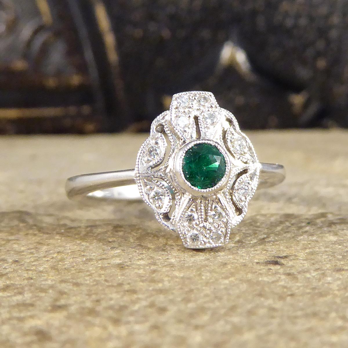 This stunning ring has been hand crafted and is new and never worn. It has been designed and carefully crafted to resemble an Art Deco style ring with a collar set bright enchanted green Emerald weighing 0.19ct in the centre with a milgrain edge