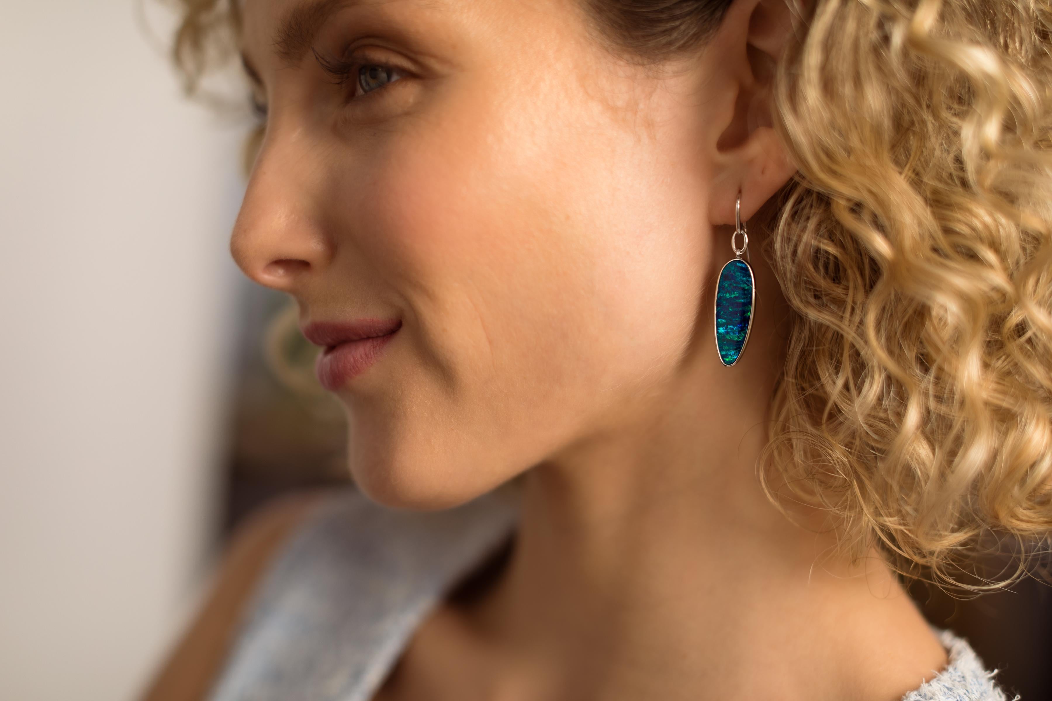 Our stunning “Ocean Odyssey” opal doublet (11.76ct) earrings features a mesmerising fusion of elegance and natural wonder. Crafted with utmost precision and finesse, these earrings boast a captivating blue-green play of colour that will leave you