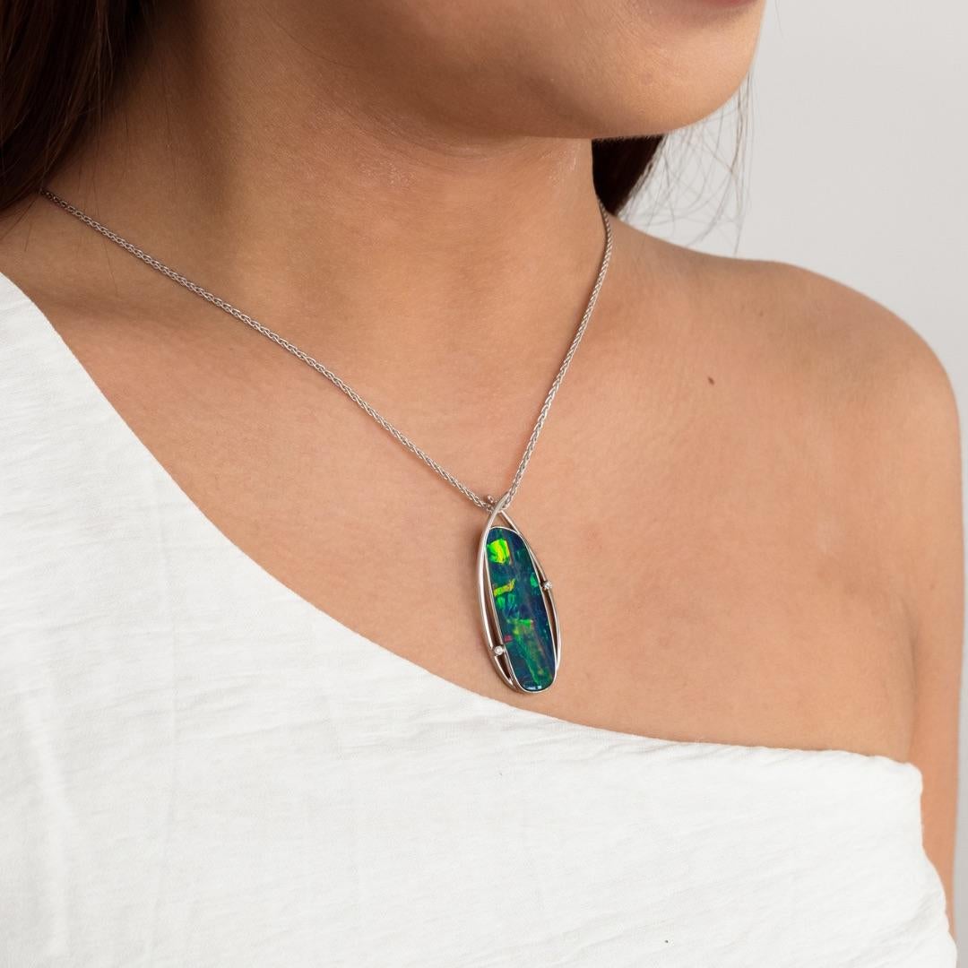 Behold the exquisite ‘Jessica’ opal pendant, adorned with a captivating opal doublet-black (9.50ct) sourced from the renowned mines of Coober Pedy, Australia. This remarkable opal gem, set in 18k white gold, is complemented by two dazzling diamonds