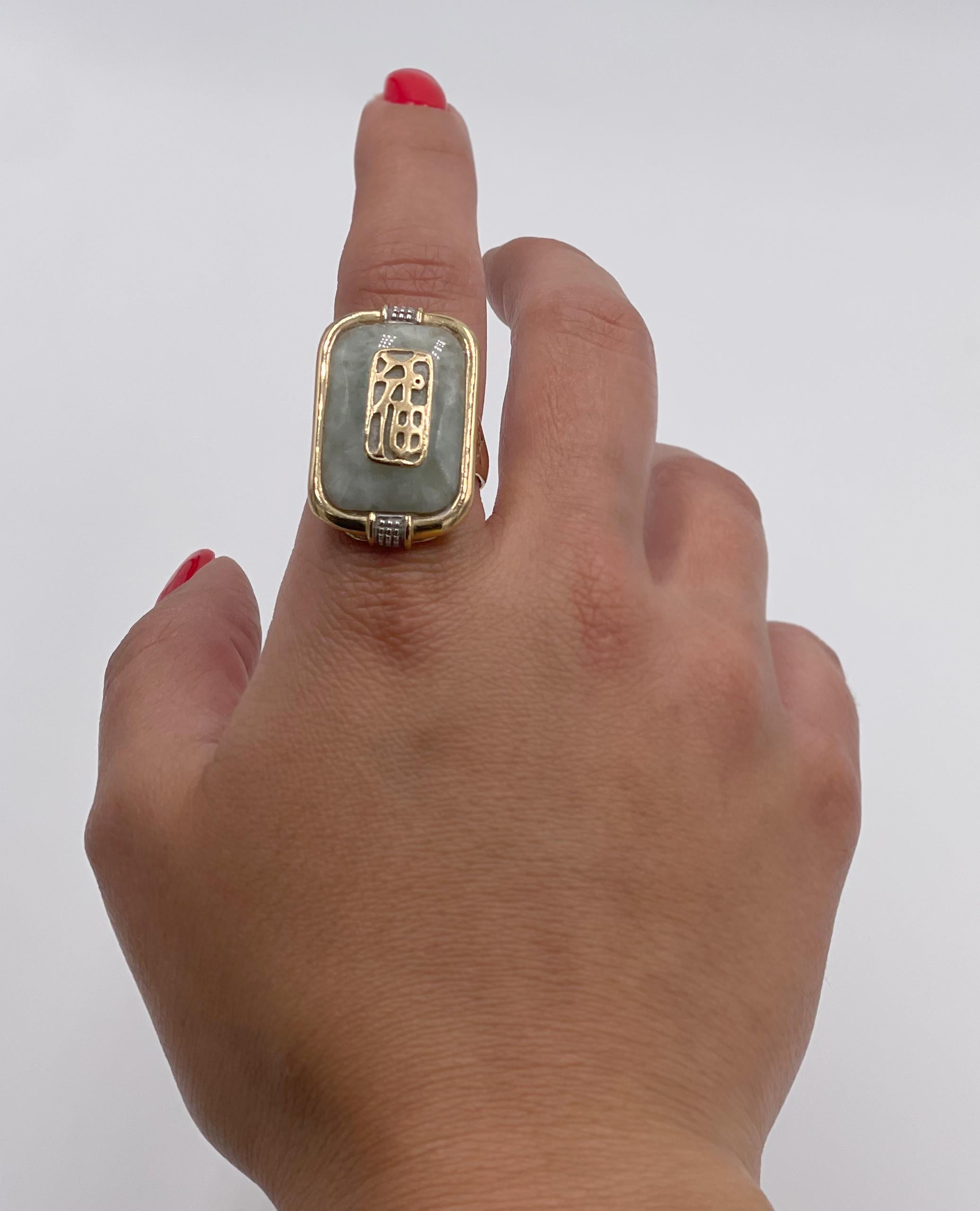 Anello usato in oro giallo 14K con simboli cinesi di fortuna e giada verde chiaro. Prodotto da Sanuk.

* Misura delle dita 9,25