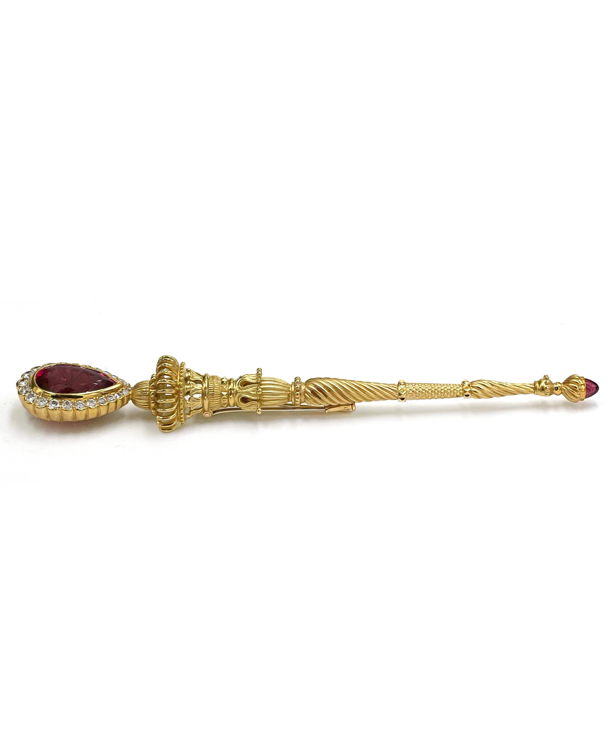 Pre owned vintage estate 18K yellow gold rubellite and diamond brooch with one bezel set faceted pear shaped rubellite weighing approximately 10.00 carats.  The stone is a deep intense slightly purple/red color.  Around the rubellite are 24 round,