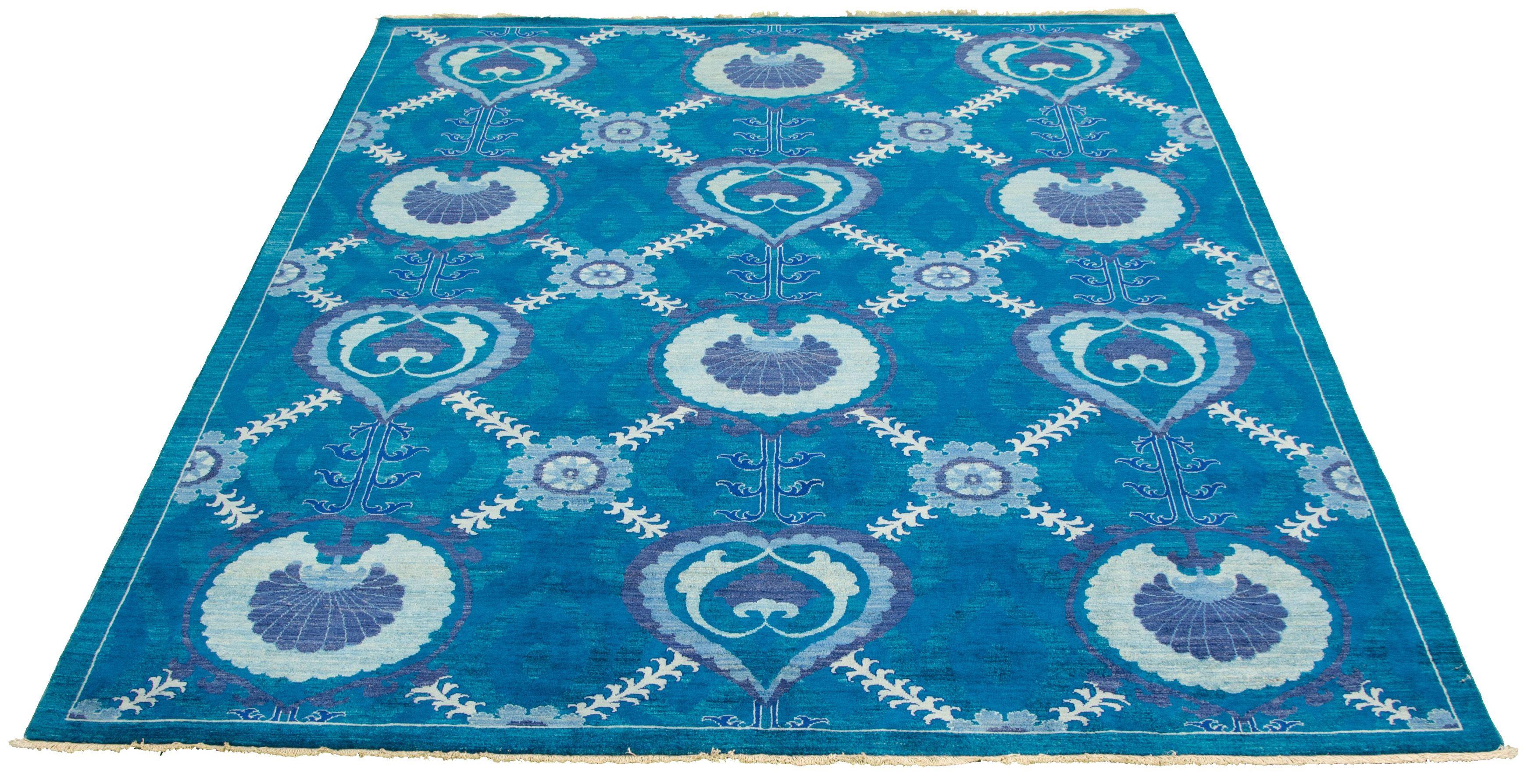 In bright blue aqua hues, this transitional Arts & Crafts Oushak carpet measures 8' x 10' and belongs to the Orley Shabahang Market Collection. Unique with its large scale and repetitive design, this carpet bridges the gap between the traditional