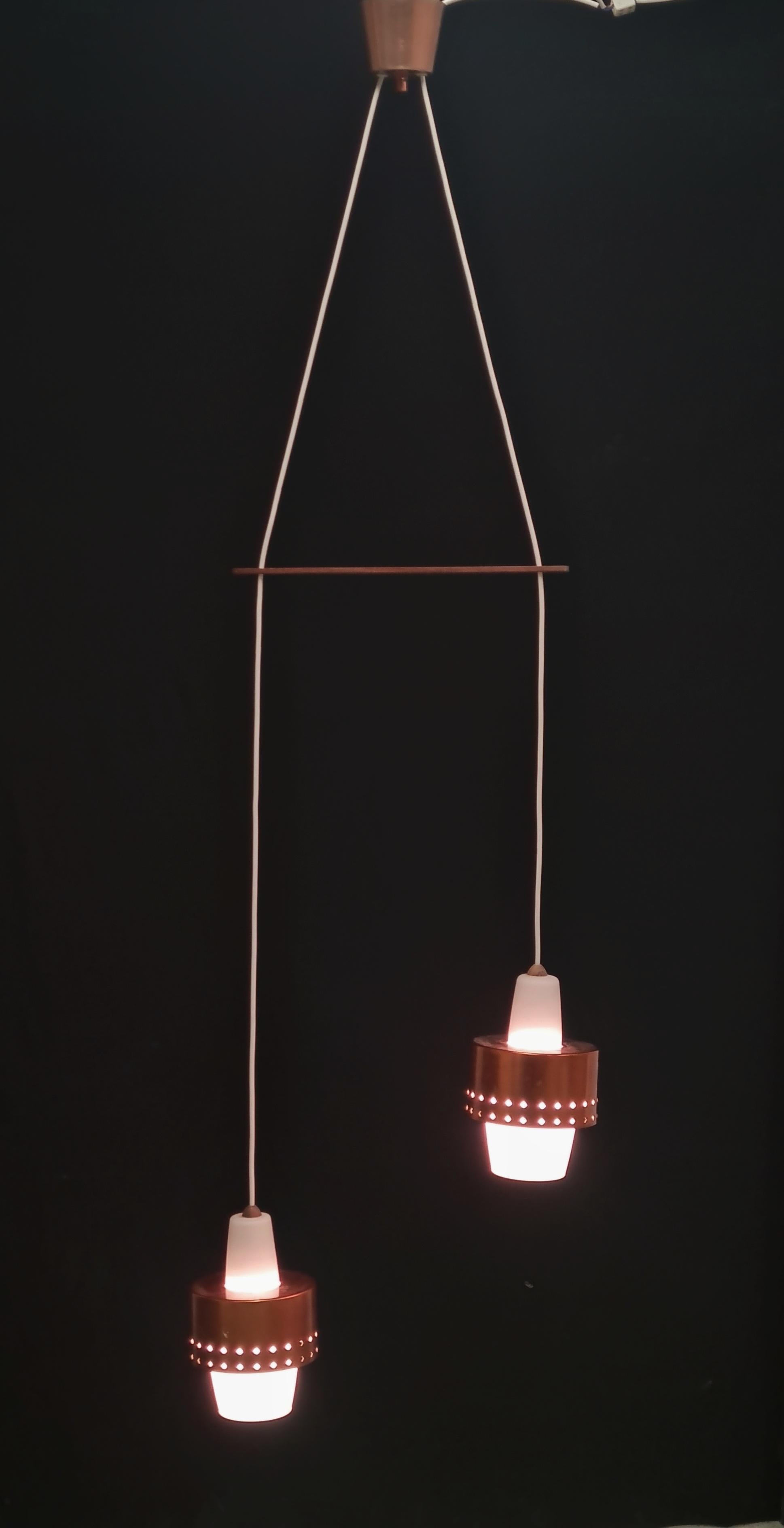 A lovely and adjustable vintage ceiling lamp by Presenta designed for Idman Oy in the 1960s. The model was sold by Idman as model K2-117/2 or /3 with three lamps. The freely hanging lights' height is adjustable and the measurement above is at their