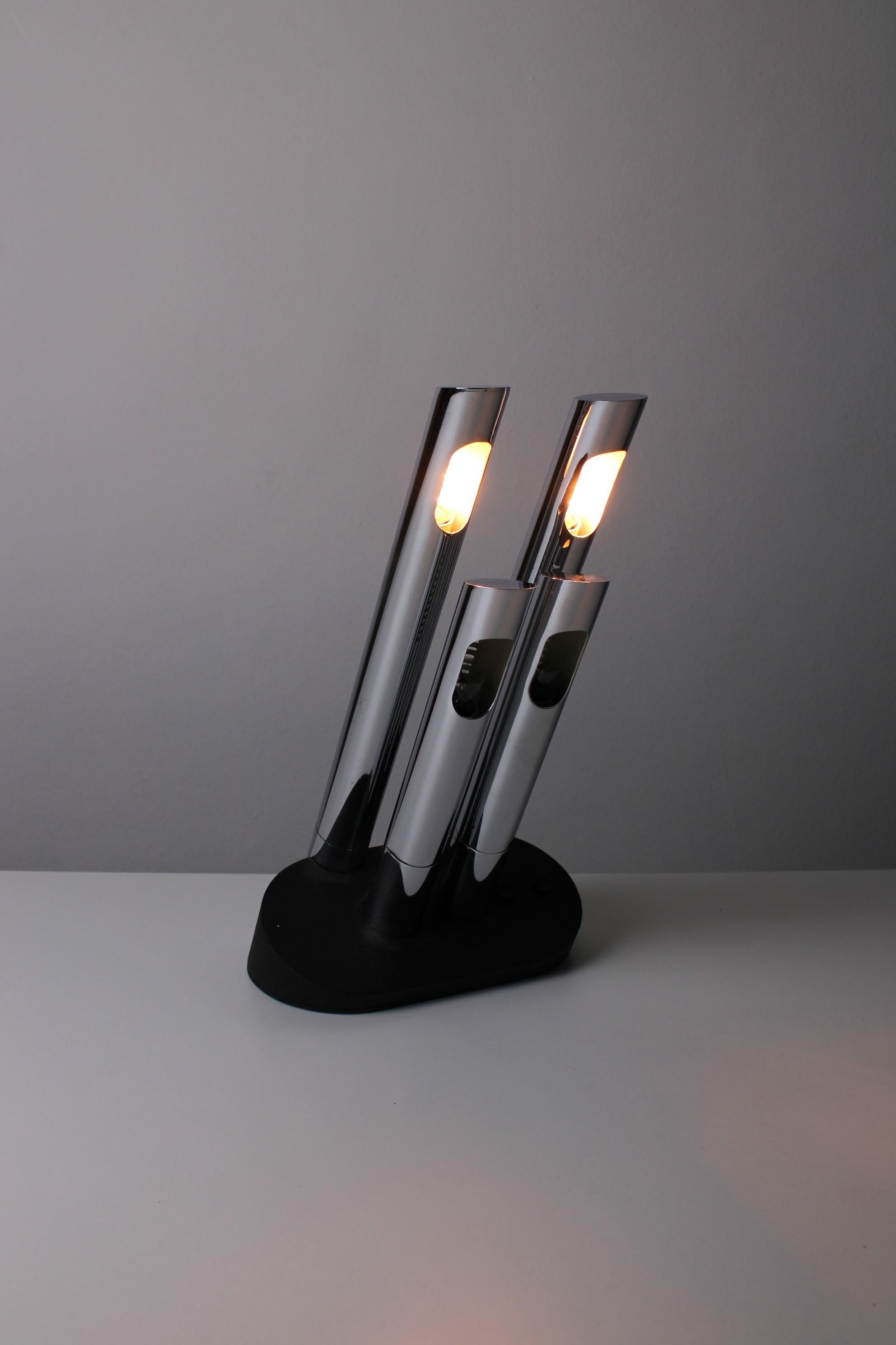Futuristic table lamp, model President (T443). Designed by Mario Faggian for Luci Illuminazione in 1974. A typical 70s design, featuring four oblique silver colored tubes and a black metal base. Each tube is equipped with a E14 socket. The lamp has