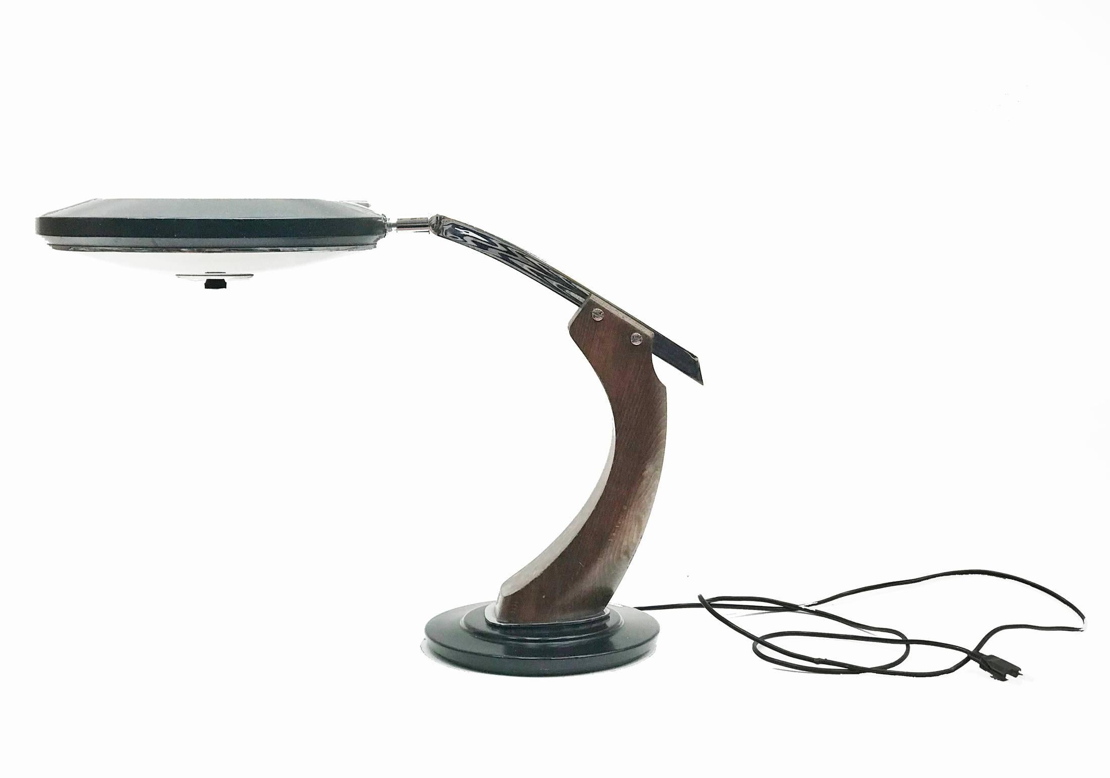 President desk lamp was conceived for management offices. The base and top of the shade are black lacquered, underneath the shade there is a glass diffuser that sifts the light and hides the bulbs. Wooden arm rotates on the base 360 degrees and the
