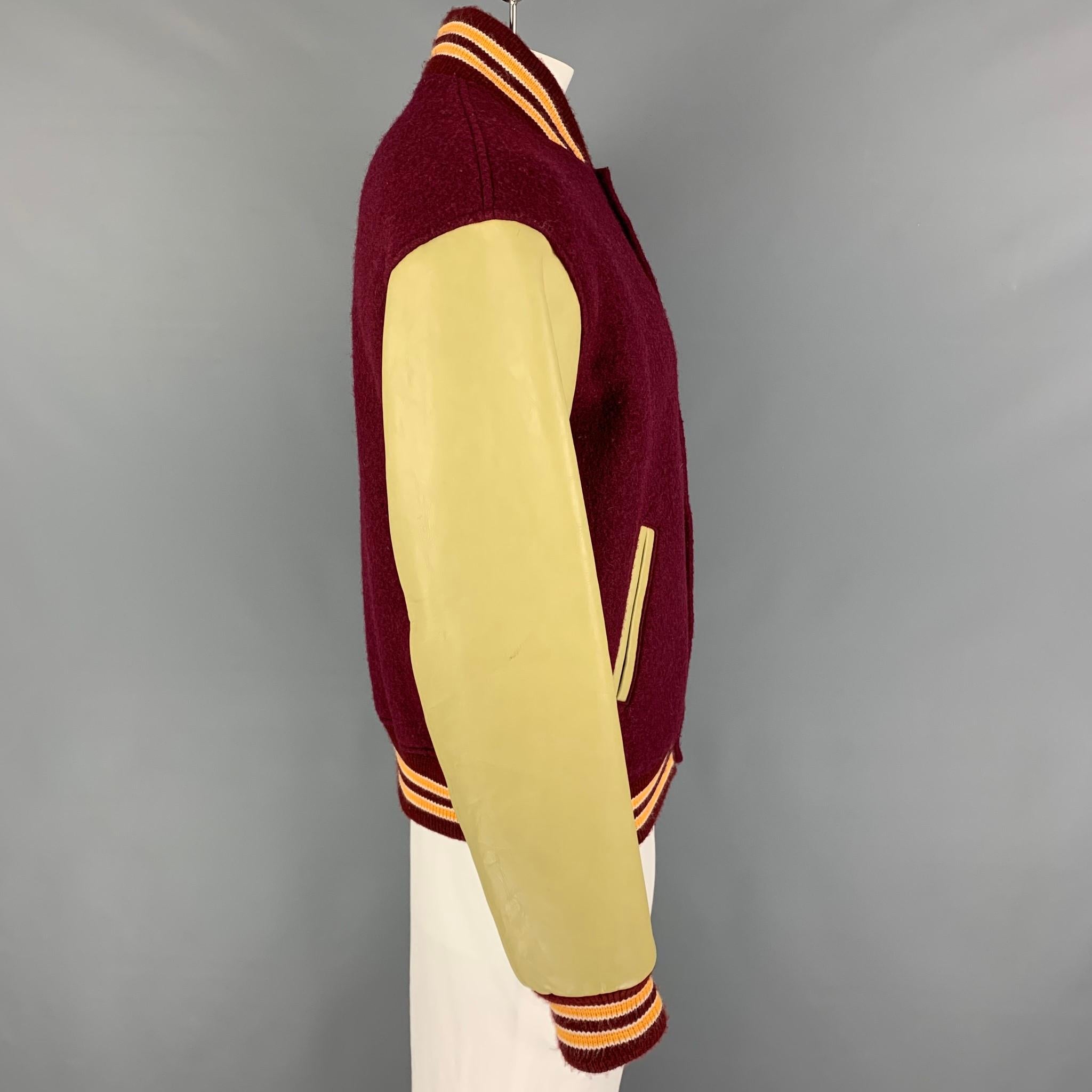 PRESIDENT's jacket comes in a burgundy & olive color block mixed materials featuring a varsity style, leather sleeves, ribbed hem, slit pockets, and a snap button closure. Made in Italy. 

Very Good Pre-Owned Condition.
Marked: