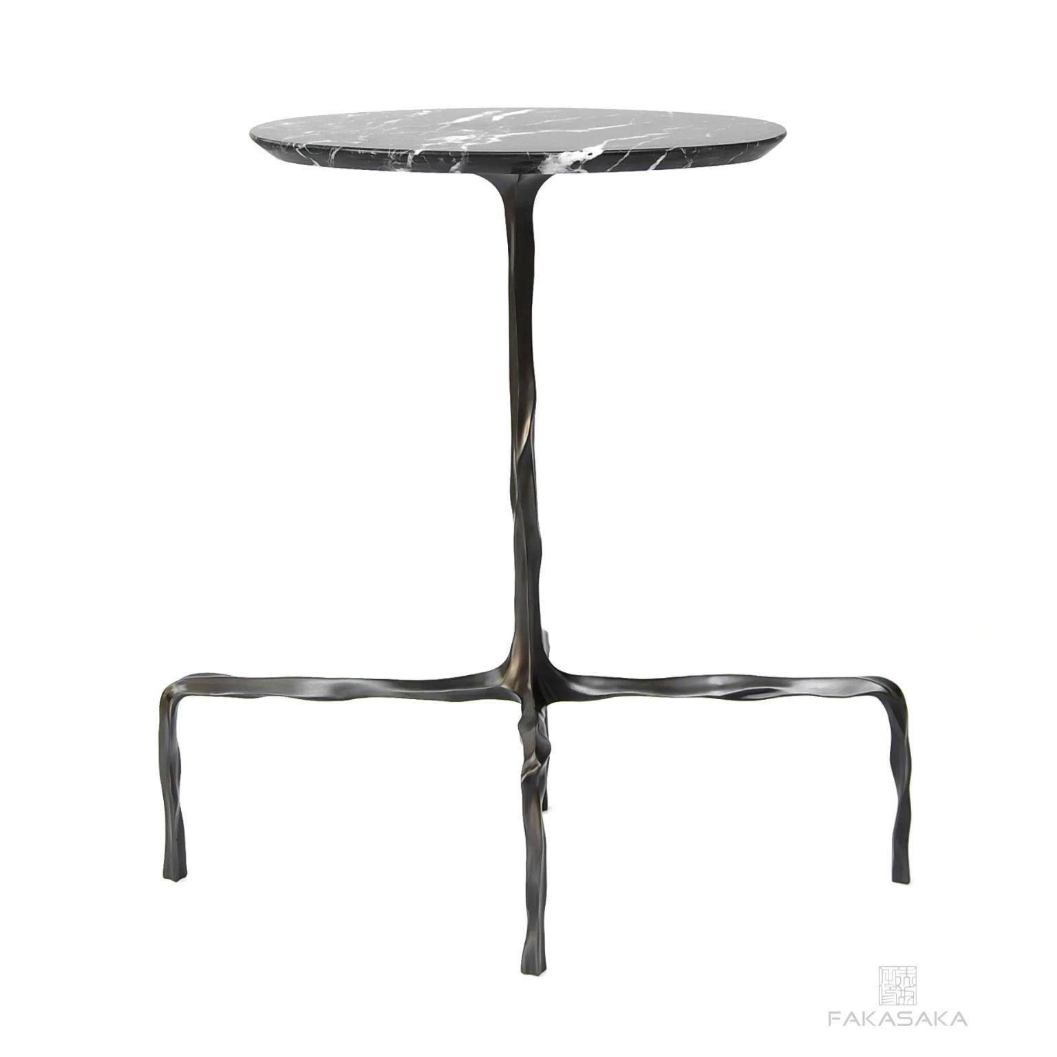 Presley drink table with Nero marquina marble top by Fakasaka Design.
Dimensions: W 58 cm D 28 cm H 60 cm.
Materials: dark bronze base, Nero Marquina marble top.
Also available in different table top materials (Agate).  

 FAKASAKA is a design