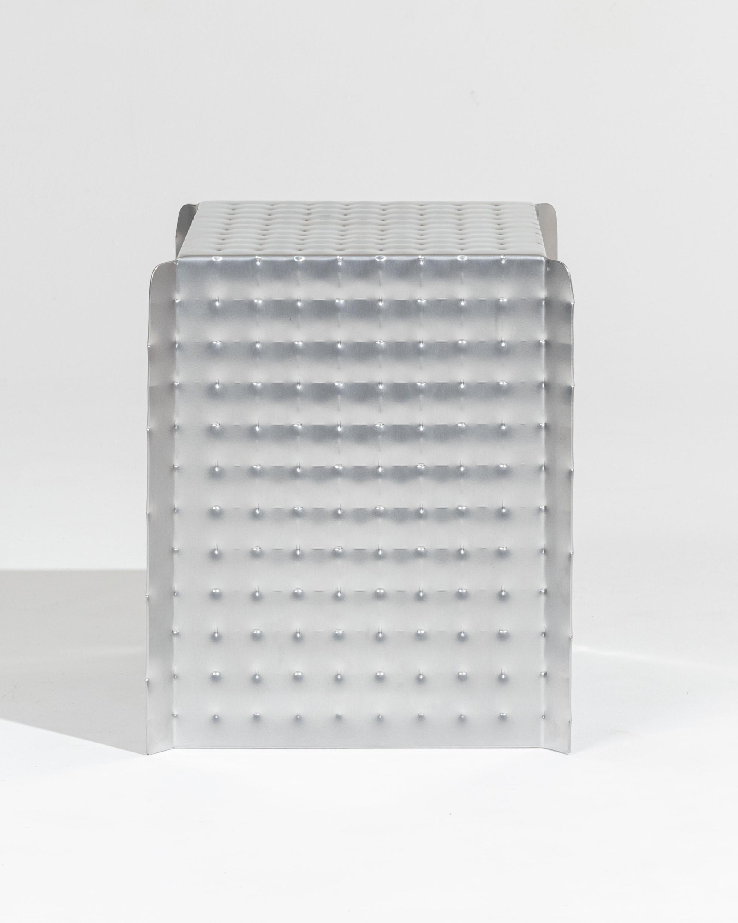 Taburete a presión de aluminio de Tim Teven.
La deformación del metal mediante presión revela detalles técnicos fascinantes, así como nuevas cualidades visuales y táctiles.
El taburete y el banco Presión se fabrican con planchas de aluminio en las