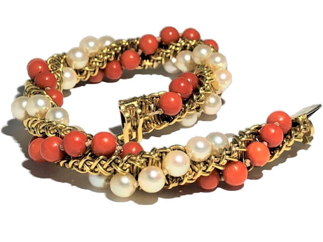 This very interesting 18k yellow gold French Cartier designed and created orange coral and Japanese cultured pearl cocktail bracelet is both casual and elegant. It is substantial in appearance with a diameter of almost 1/2 inch and a length of 7 3/8