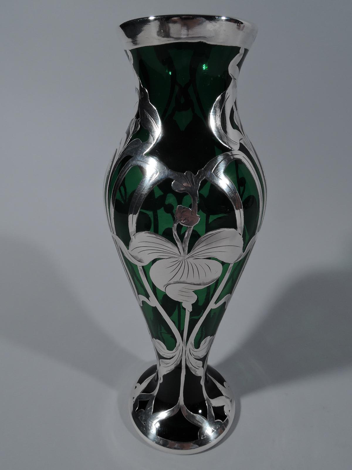 Pretty turn-of-the-century American Art Nouveau green glass vase with engraved silver overlay. Baluster flowing into round foot; short neck and flared rim. Semi-abstract floral pattern with loose and twisted petals, and entwined stems.