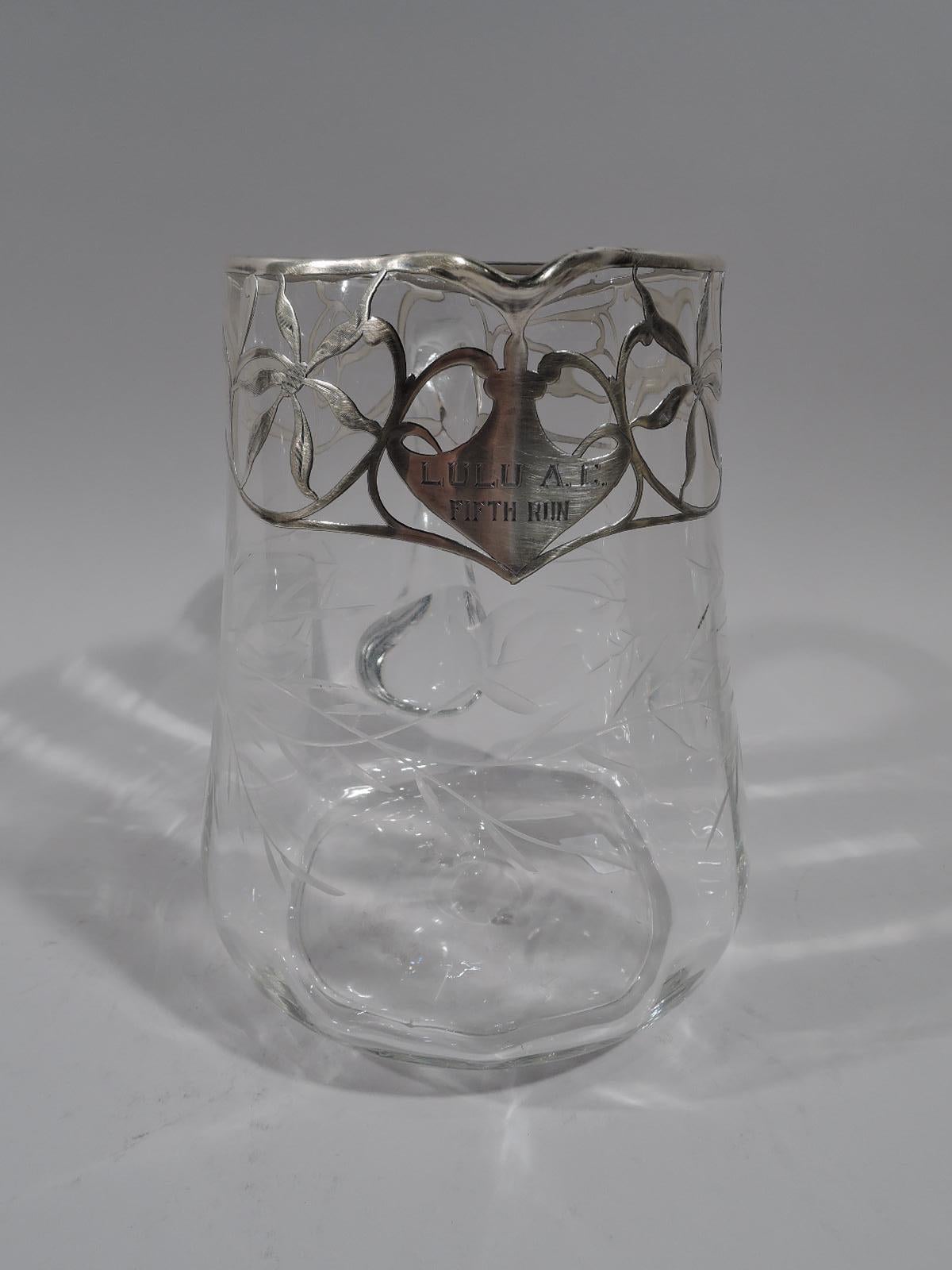 Pretty American Edwardian Art Nouveau clear glass and silver overlay water pitcher, circa 1915. Upward tapering handle with gentle base lobing and c-scroll handle. Bold and stylized flower heads acid-etched on sides. Loose and open scroll and floral