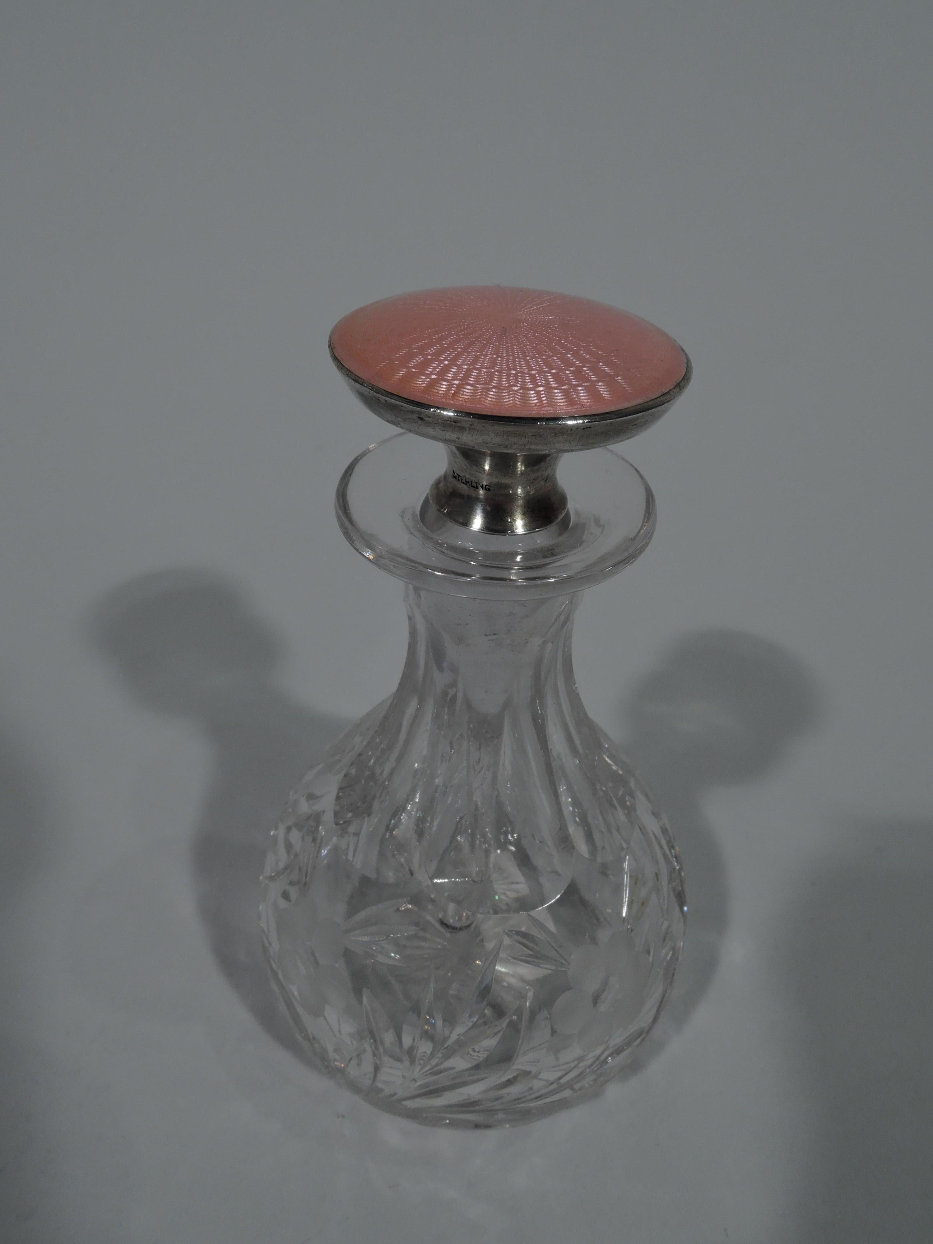 Pretty American Edwardian perfume, ca 1910. Ovoid crystal battle with acid-etched and stylized flower branch and faceted neck. Stopper sterling silver with radiating pink guilloche top and dagger plug. Stopper marked “Sterling”. 
