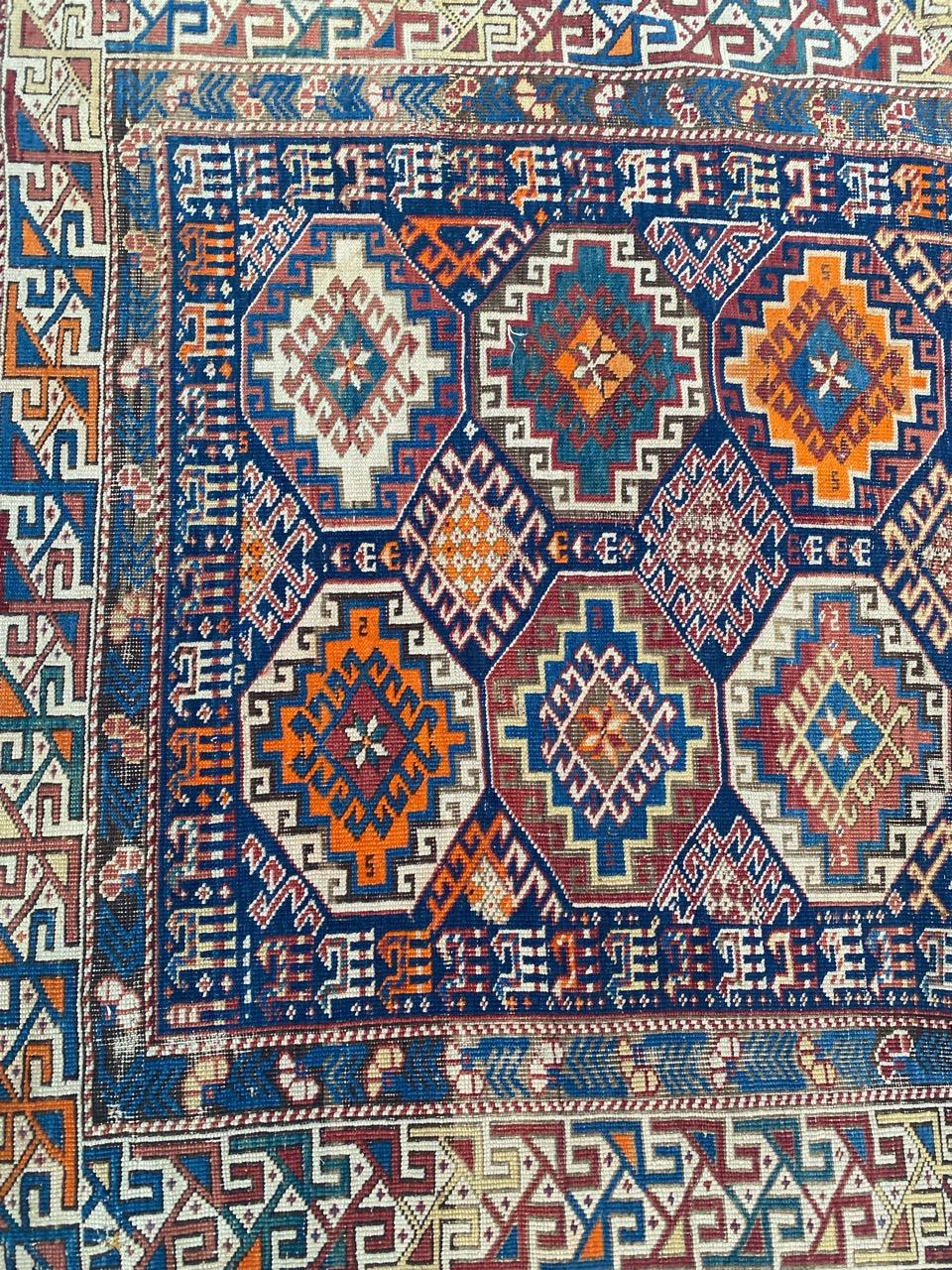Exquisite late 19th-century Caucasian rug featuring a stunning Moghan design with intricate geometric patterns. Hand-knotted with wool velvet on a wool foundation, this masterpiece boasts natural colors. Against a navy blue backdrop, stylized