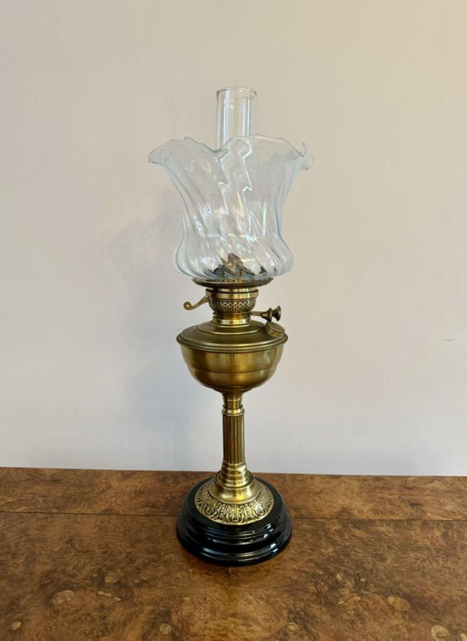 Pretty antique Edwardian quality oil lamp, having the original glass shade with a wavy shaped edge, a glass chimney, a brass burner, supported by a brass column, raised on a circular base.

D. 1900