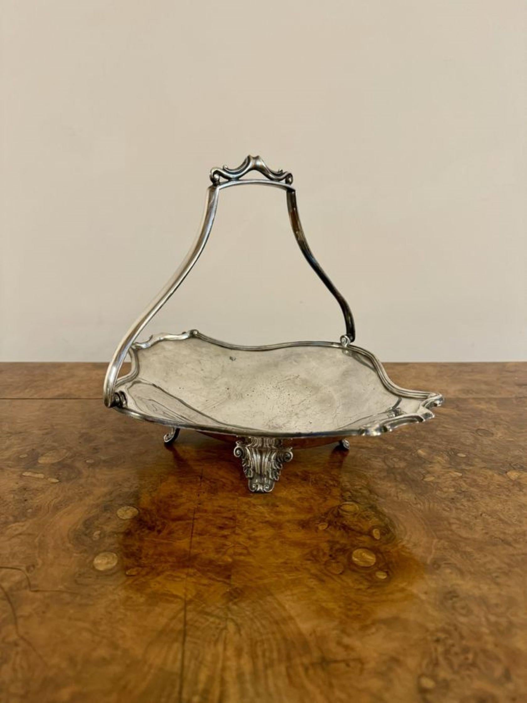 Joli panier à gâteau antique en métal argenté de style édouardien. Ce panier à gâteau antique en métal argenté de style édouardien est doté d'une poignée en forme de balancier sur le dessus et repose sur quatre pieds ornementés en forme.

D. 1900