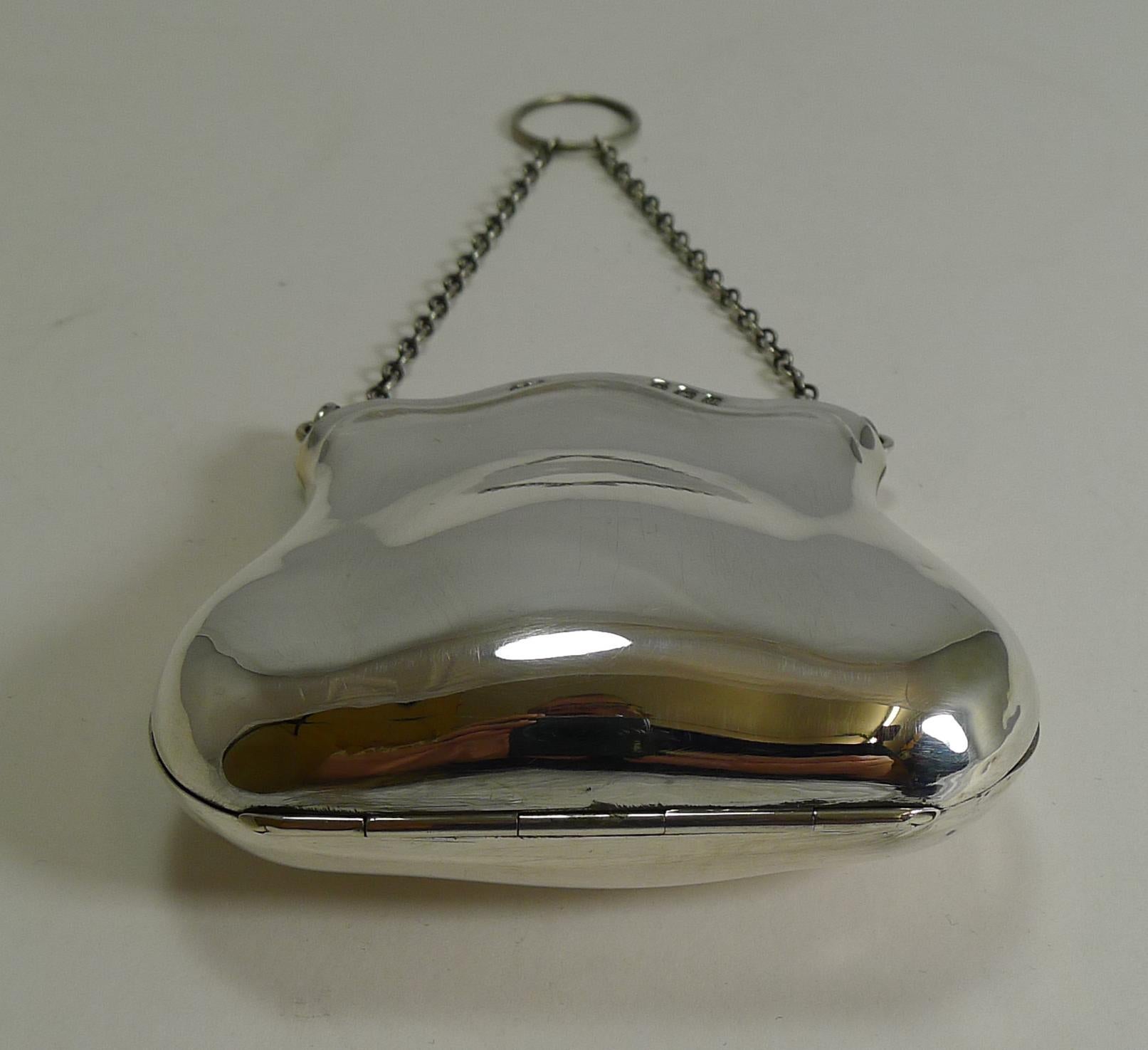 This beautifully shaped purse with it's simplistic design creates a really elegant example.

Made from English sterling silver including the chain and finger ring, it is fully hallmarked for Birmingham 1919; the makers initials are also present