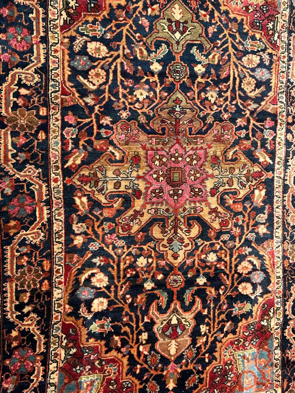 Beautiful early 20th century Sarouk rug with nice design with a central medallion and stylized floral design, and nice natural colours with pink, red, orange, yellow, blue, navy blue, green and white, entirely and finely hand knotted with wool on