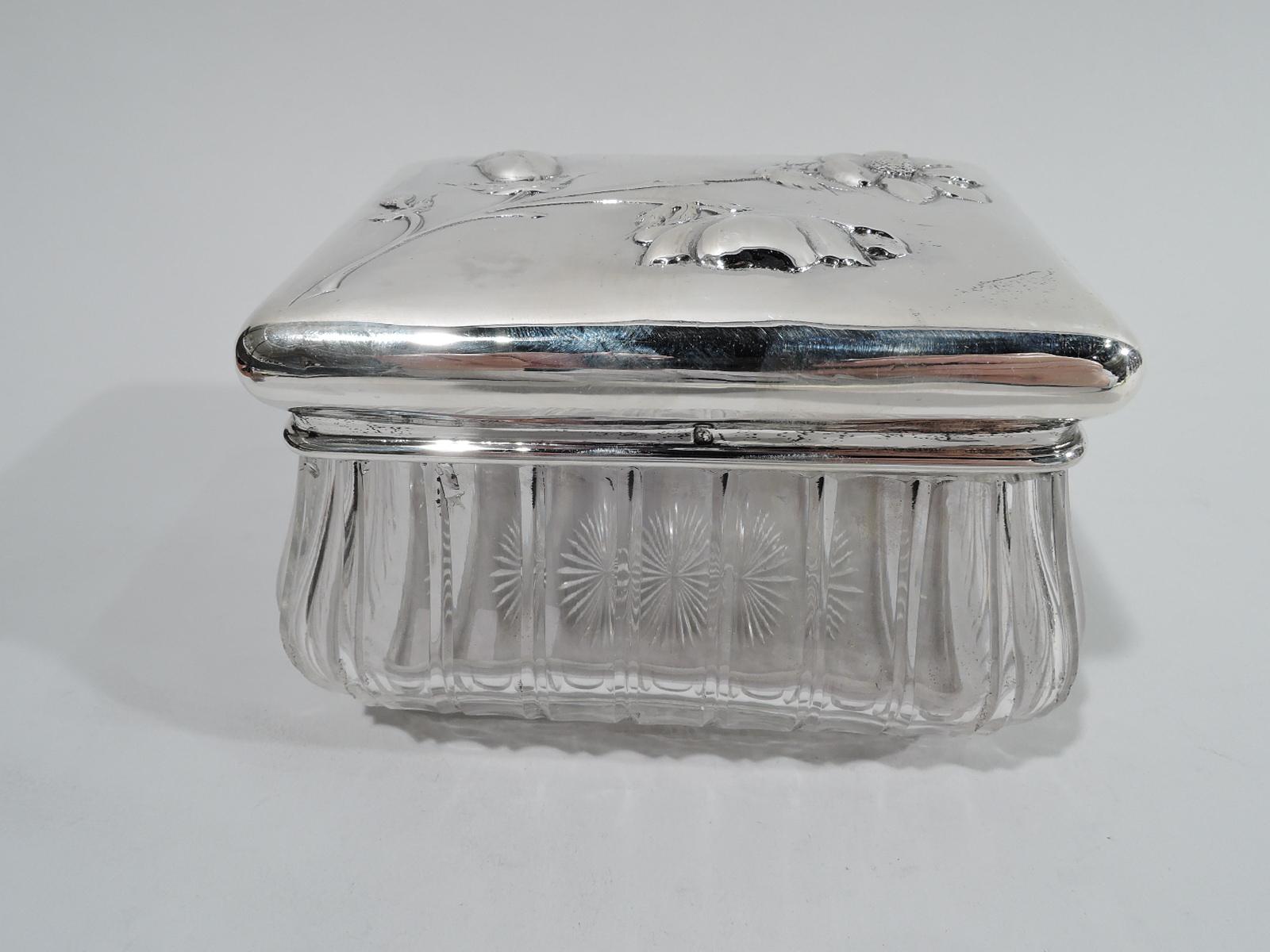 French glass jar with 950 silver mount and cover, ca 1920. Rectangular and bombé with fluted sides and short inset foot with cut star. Collar silver as is cover with curved sides; top raised with chased flowers in various stages of blooming. Pretty