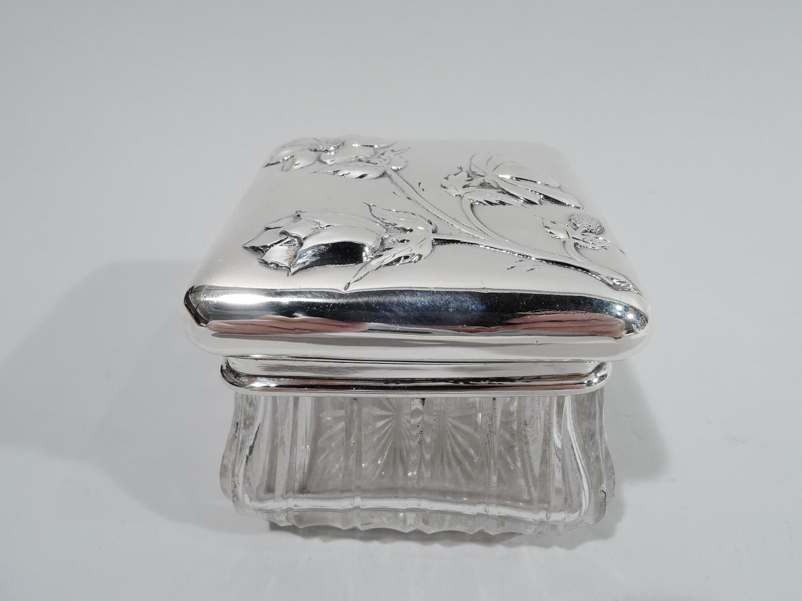 French glass jar with 950 silver mount and cover, ca 1920. Square and bombé with fluted sides and short inset foot with cut star. Collar silver as is cover with curved sides; top raised with chased flowers in various stages of blooming. Pretty with