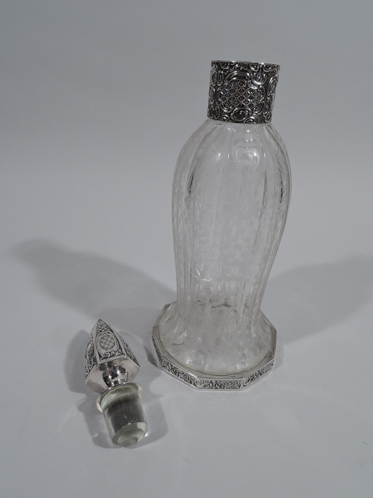Pretty German 800 silver and crystal decanter, ca 1910. Curved and faceted crystal body flowing into spread base; acid-etched flowers, leaves, and scrolls. Drum-form neck in silver collar with tooled flowers and scrolls. Silver ovoid and faceted