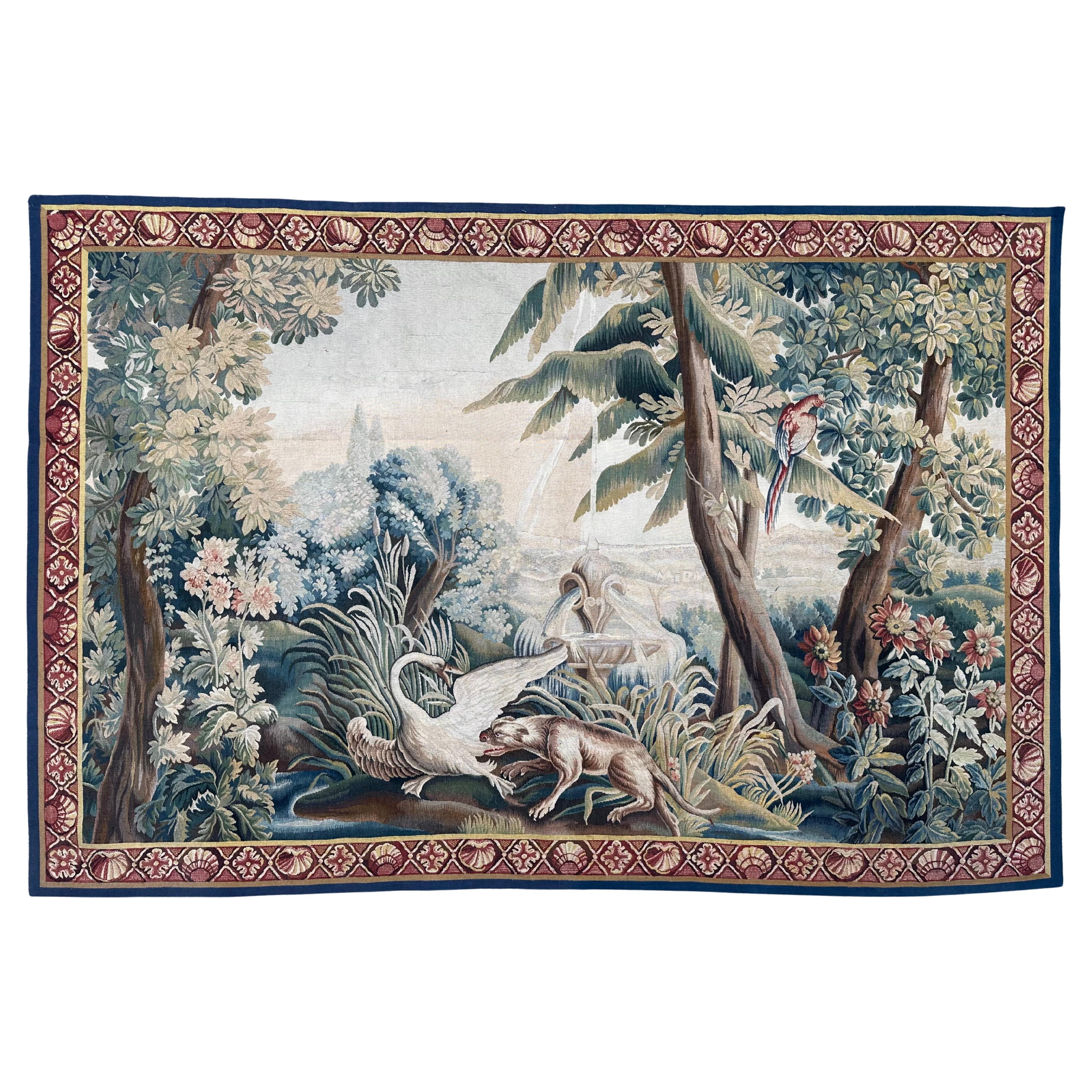 Découvrez l'élégance intemporelle de cette grande tapisserie française d'Aubusson du début du XXe siècle, dont le motif captivant s'inspire des tapisseries de verdure du XVIIIe siècle. 
 Cette tapisserie s'inspire d'Un cygne attaqué par un chien,