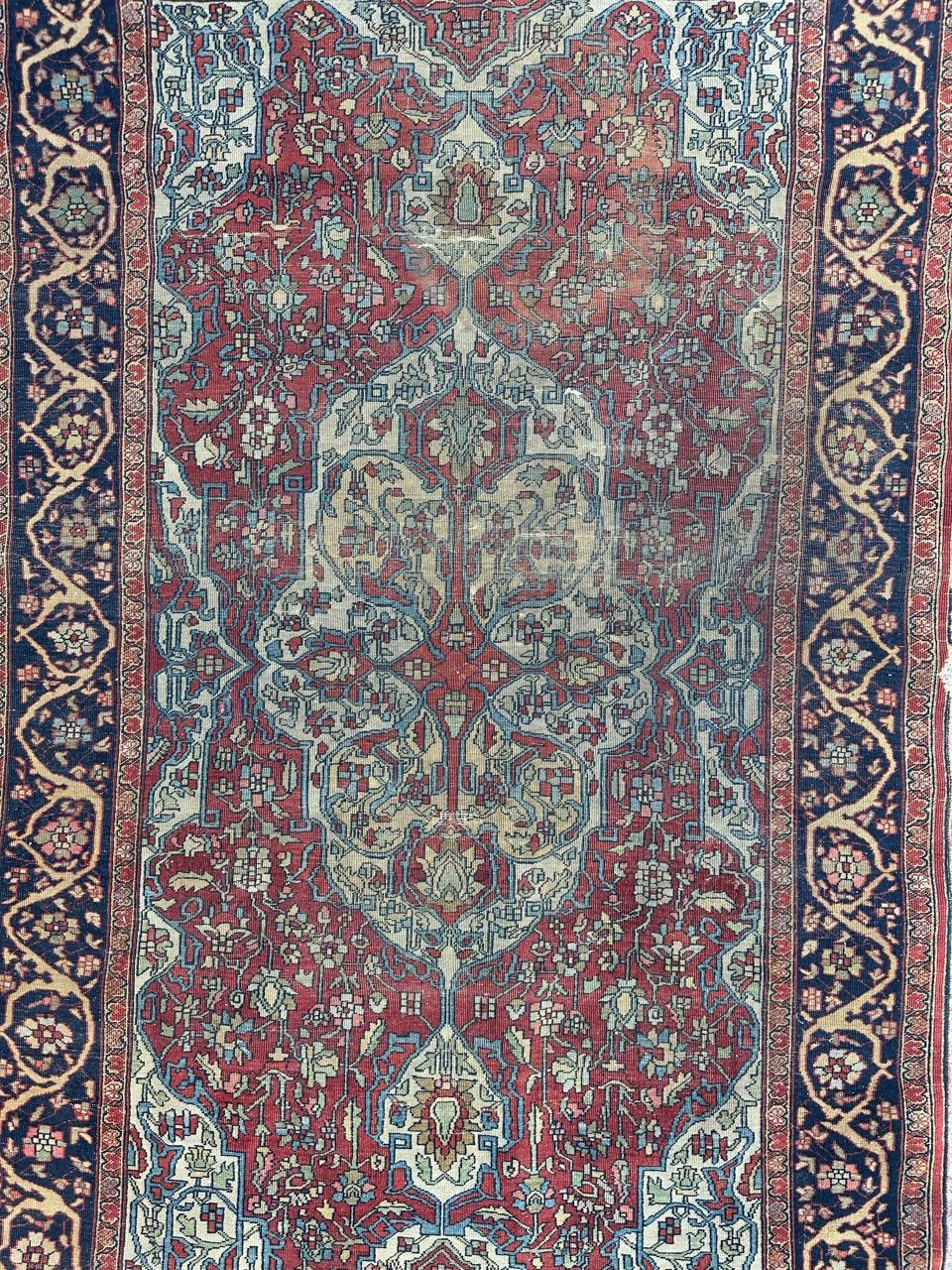 Exquisite antique Sarouk Ferahan carpet, intricately handwoven towards the late 19th century. This stunning piece features a symmetrical, stylized floral motif with a central white medallion surrounded by vibrant red, light blue, and pale green