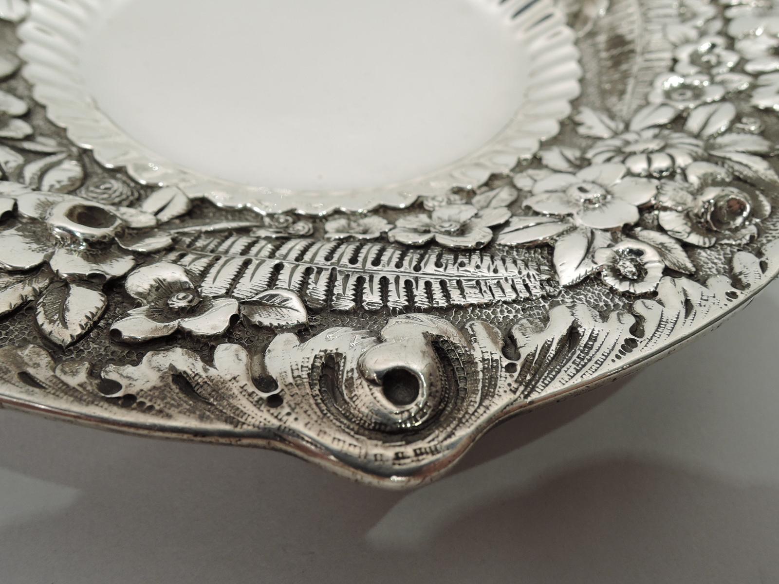 Pretty Victorian sterling silver dish. Made by Tiffany & Co. in New York. Round and plain well with fluted border. Shoulder wide and tapering with allover floral and fern repousse. Irregular leaf rim. Fully marked including maker’s stamp, pattern