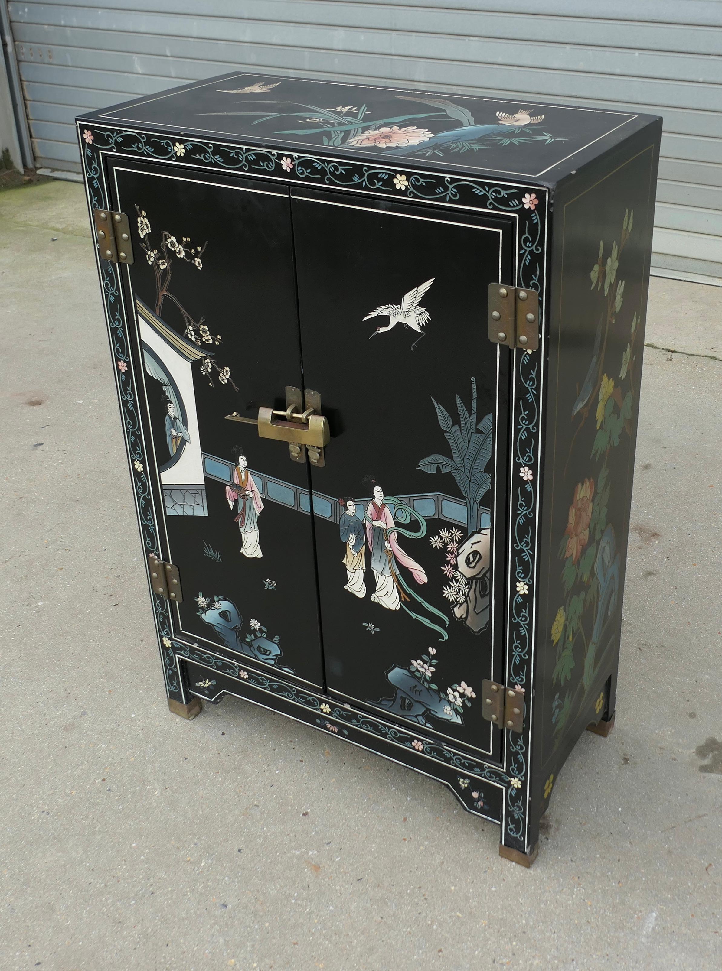 Pretty Chinoiserie Cupboard Decorated with Birds and Flowers

The cupboard is in black lacquer and colourfully carved and painted  with Birds, characters and and chrysanthemums, it has 2 doors, these have a large oriental lock complete with key and