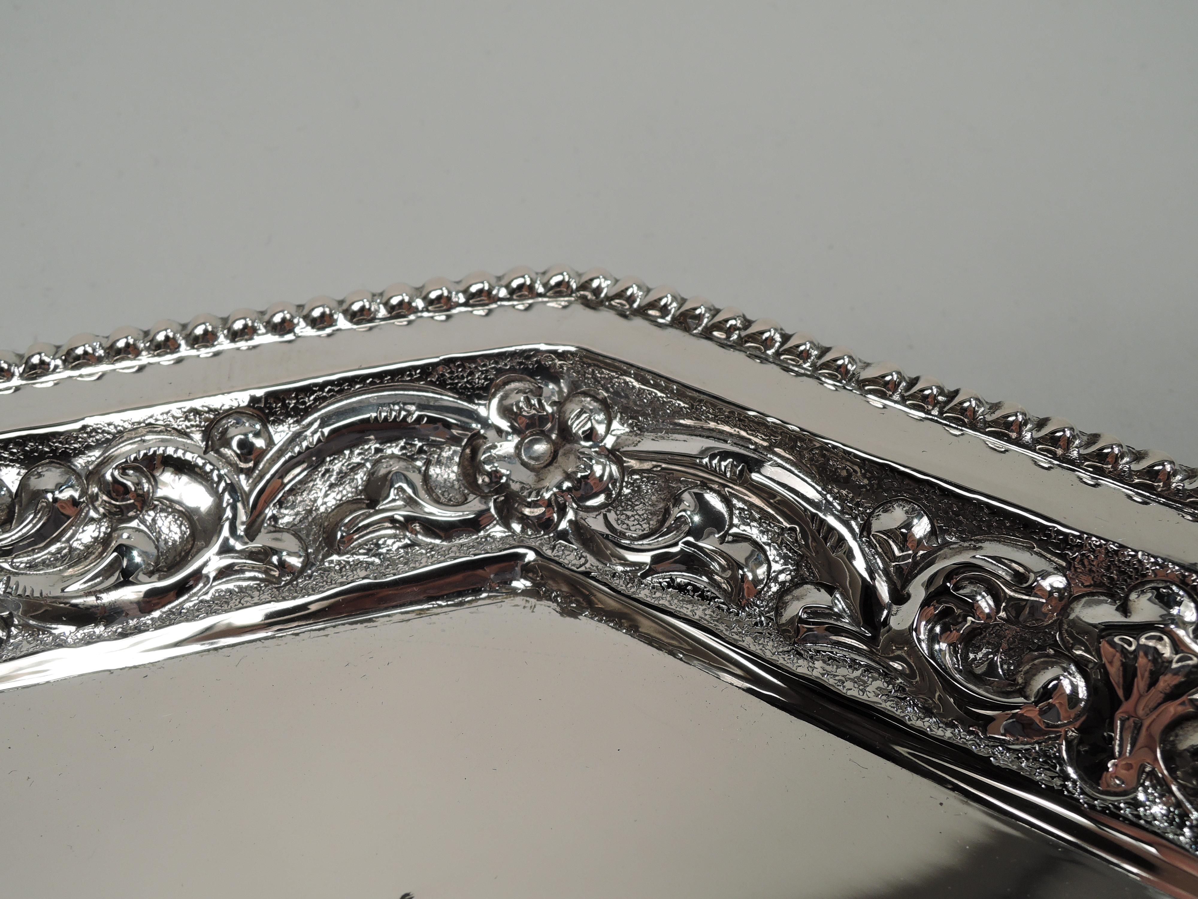 Pretty Classical Silver tray. Octagonal. Sides tapering with repousse leafing scrollwork and flowers; rim beaded. Marked “Silver”. Weight: 22.9 troy ounces.  