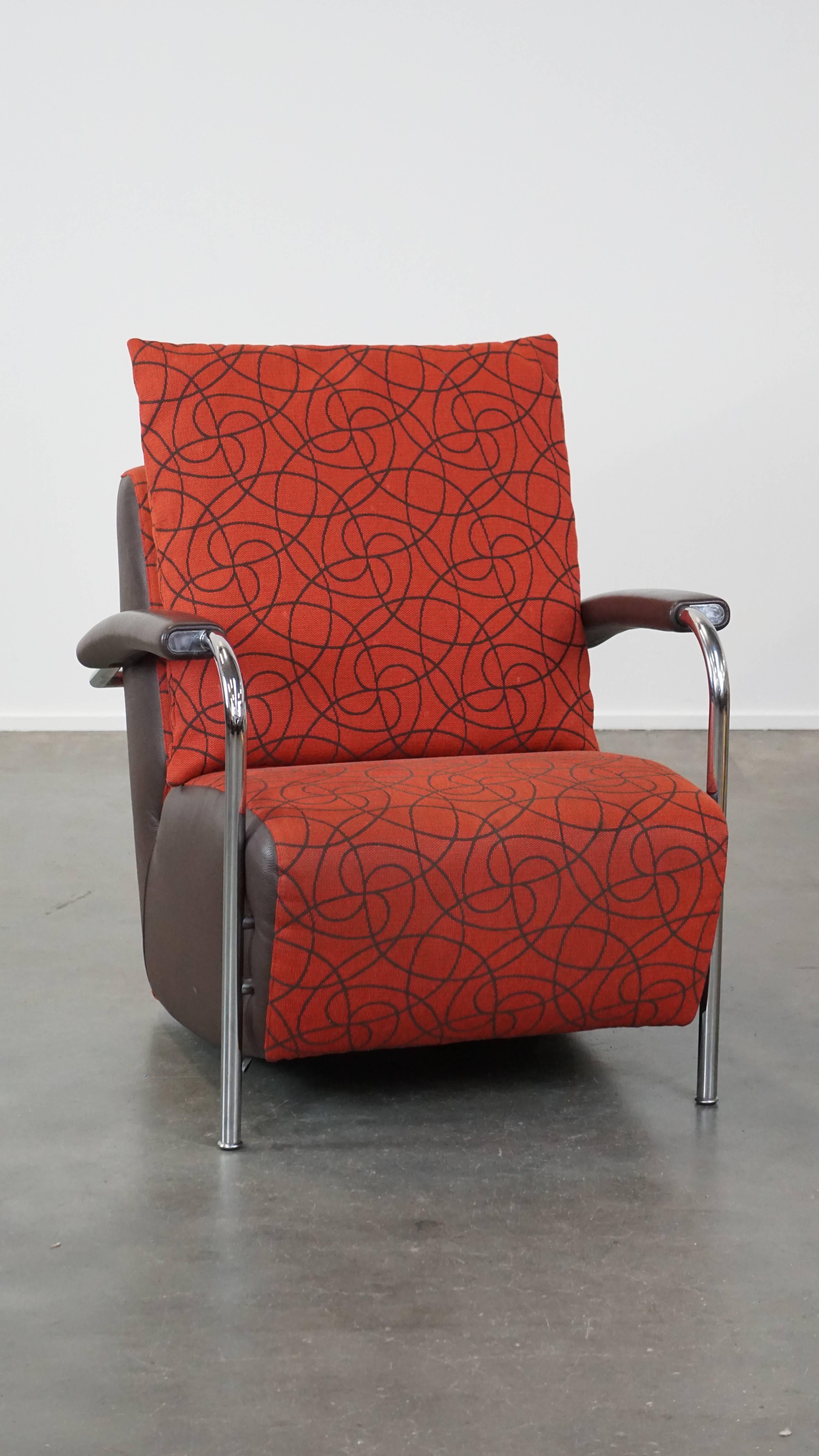 Cet étonnant fauteuil Leolux, modèle Scylla, attire tous les regards et constitue un complément fantastique pour les amateurs de meubles design intemporels. Ce fauteuil présente une structure chromée, avec des assises en cuir marron et en tissu